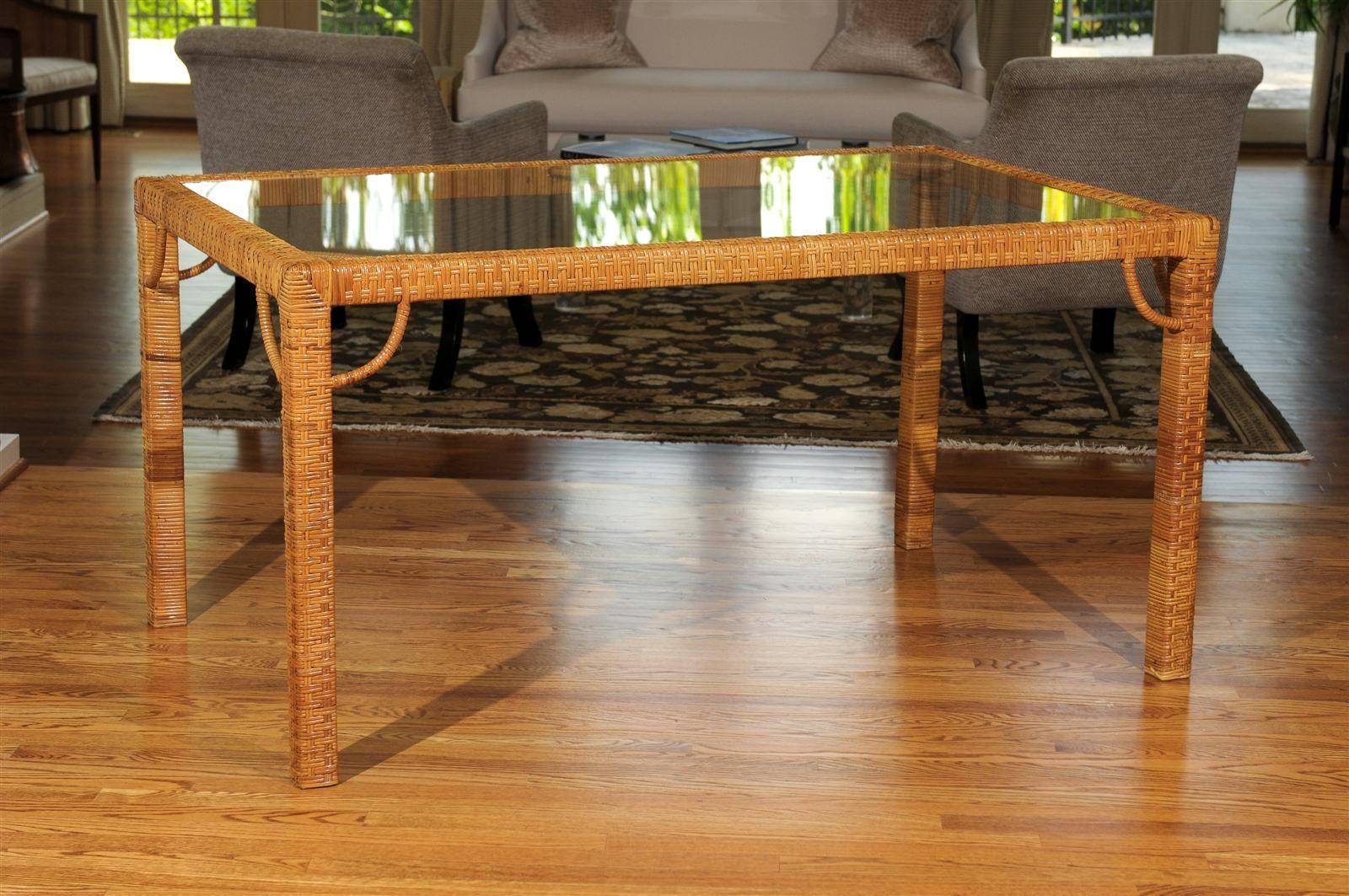 A stunning vintage Parsons style dining table or writing desk, circa 1975. Stout hardwood construction, completely veneered in a basket weave rattan raffia and aged to absolute perfection. Beautiful quarter-circle detail highlight the corners.