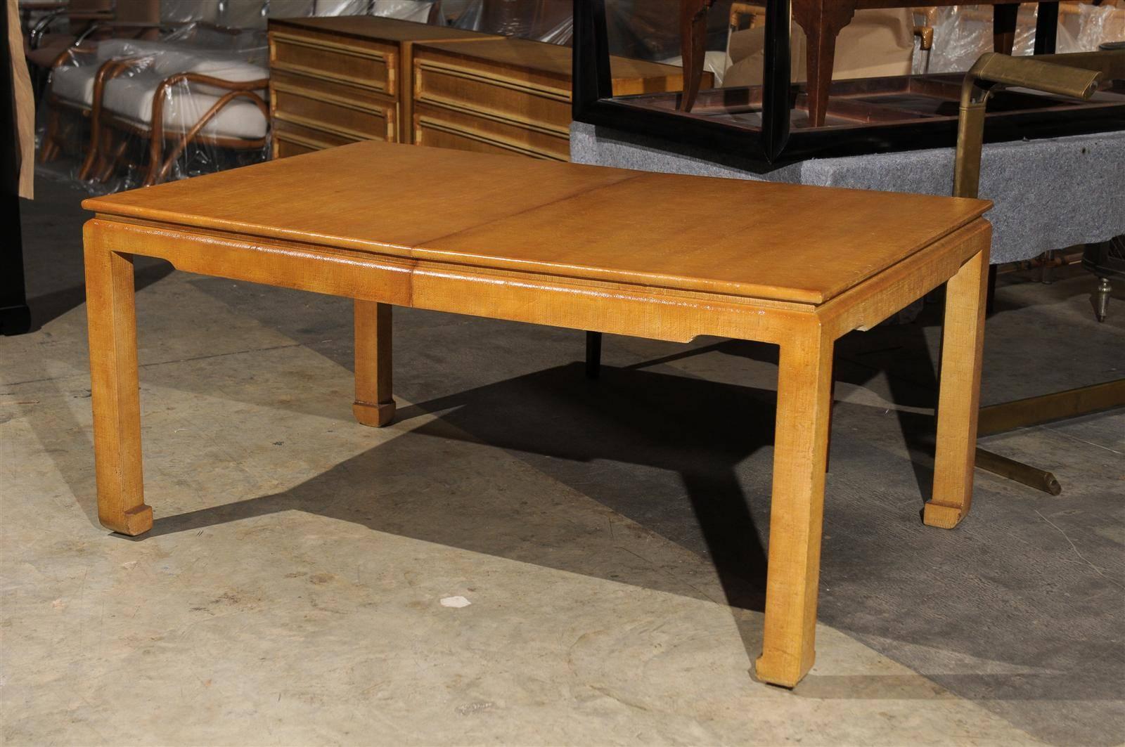 A stunning extension dining table, circa 1975. Expertly crafted hardwood construction veneered in a textured raffia, beautifully aged to perfection. Total elegance! The table is 64