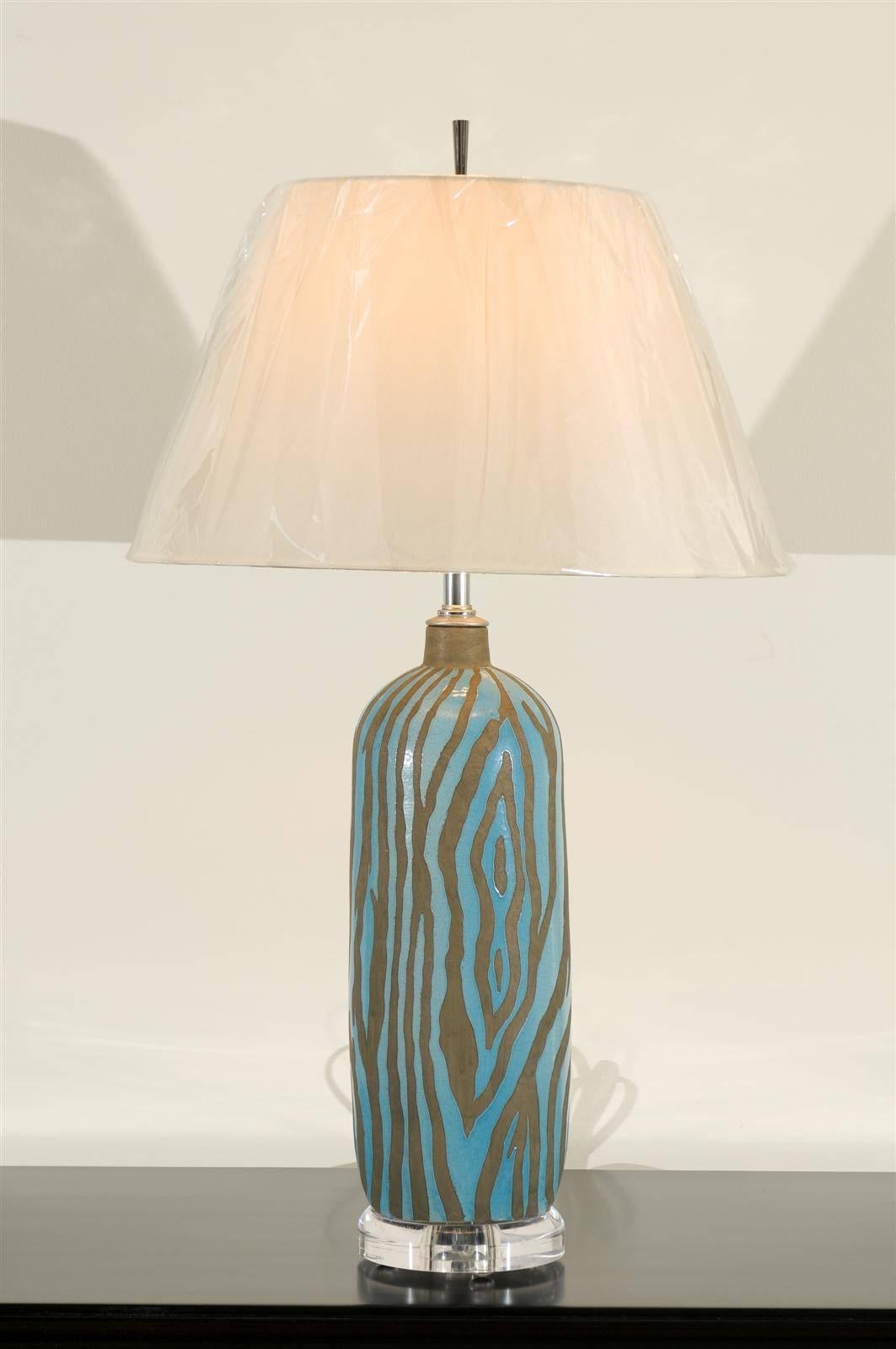 A stylish pair of ceramic vessels as custom lamps. Wonderful graphic zebra print with nickel accents on a thick Lucite museum display base. Stunning jewelry! Excellent restored condition. Wired using clear cord; new nickel three-way sockets with
