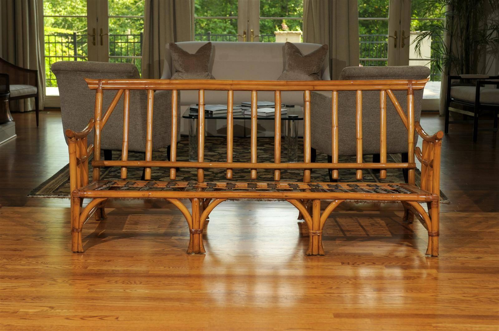 An exceptionally rare sofa by the Calif-Asia Company, circa 1960. Coveted one piece frame. Beautifully crafted rattan and hardwood construction with fabulous style and attention to detail. Stout, sturdy and suitable for heavy regular use. This firm