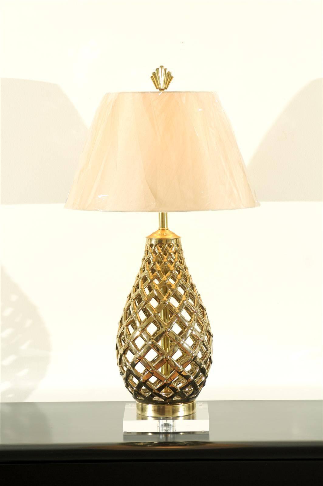 A beautiful pair of vintage lamps, circa 1980. Pierced ceramic vessels glazed to portray the look of solid brass, with solid brass accents, atop a Lucite base. Fabulous design and quality. Exquisite jewelry! Excellent restored condition. Rewired