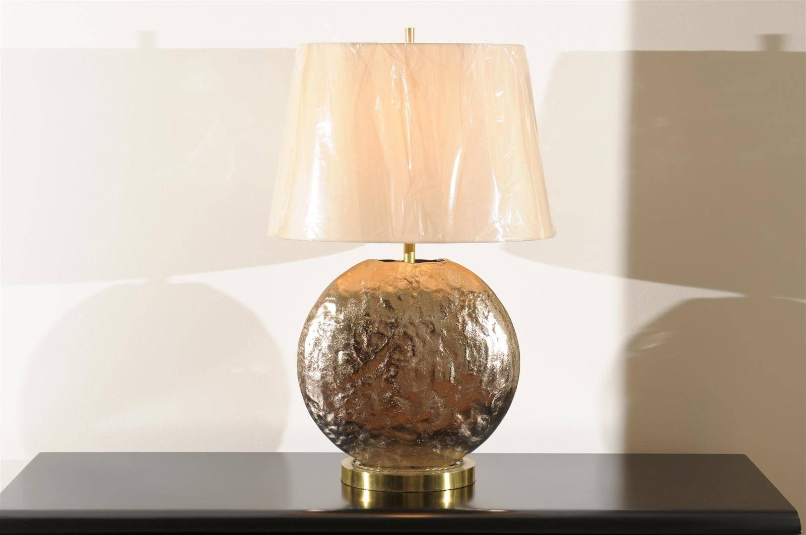 A fabulous pair of vintage medallion style lamps, circa 1975. Textured cast steel with a Champagne finish on a oval base of brass. Heavy, beautifully crafted pieces which emit a sophisticated Brutalist vibe. Statement jewelry ! Excellent restored