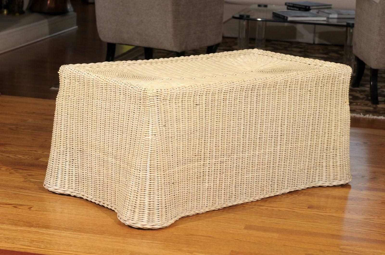 A fabulous glaze vintage wicker coffee table, circa 1970. A beautifully conceived and executed design, the wicker is woven to create a table drape effect. Hardwood frame beneath add strength and stability. This dramatic piece is a wonderful way to