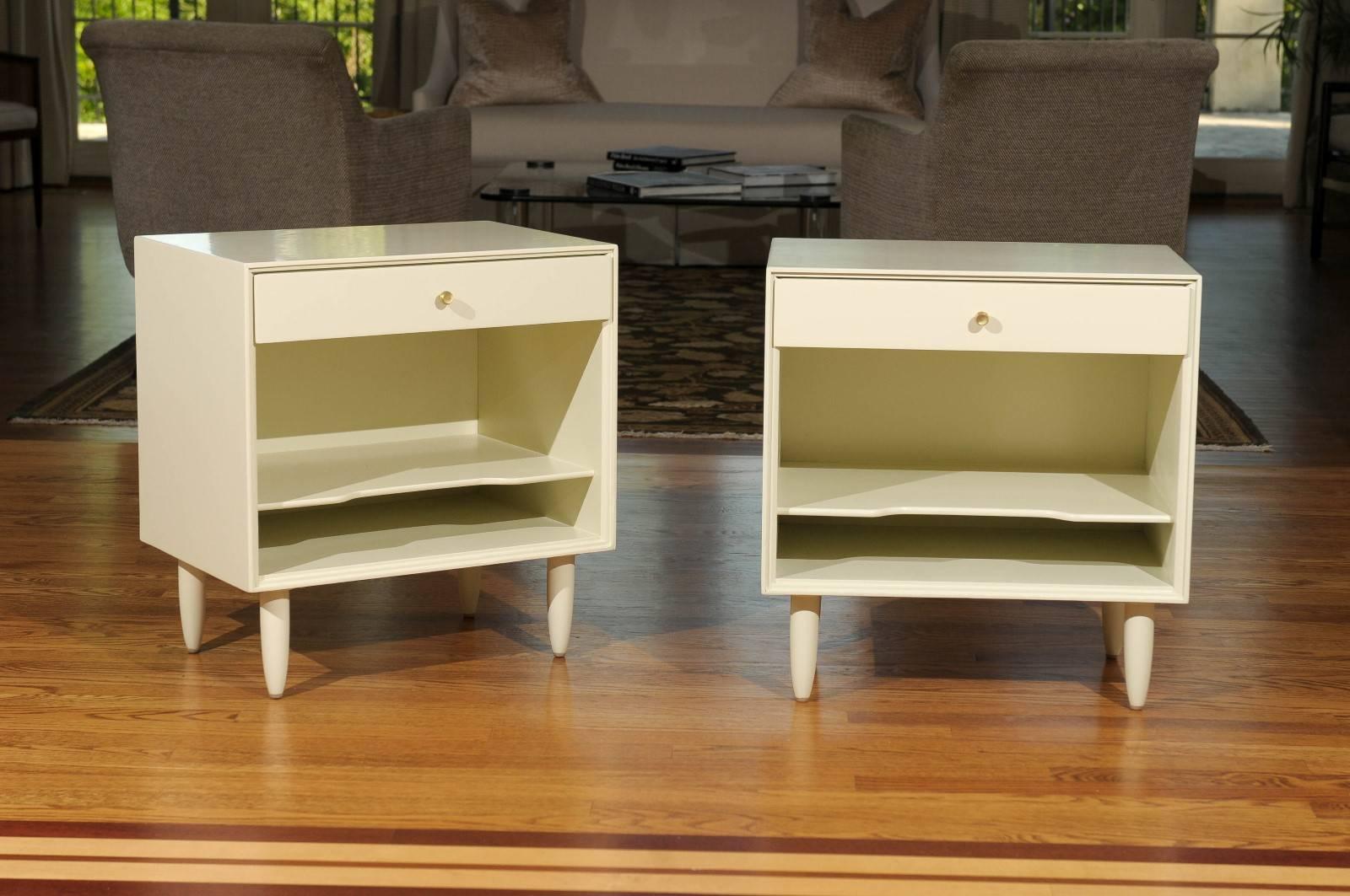Beautiful pair of end tables or nightstands by John Stuart, circa 1965. Expertly crafted mahogany case construction with great form and detail. Fabulous jewelry! Excellent restored condition. The tables have undergone a meticulous restoration,