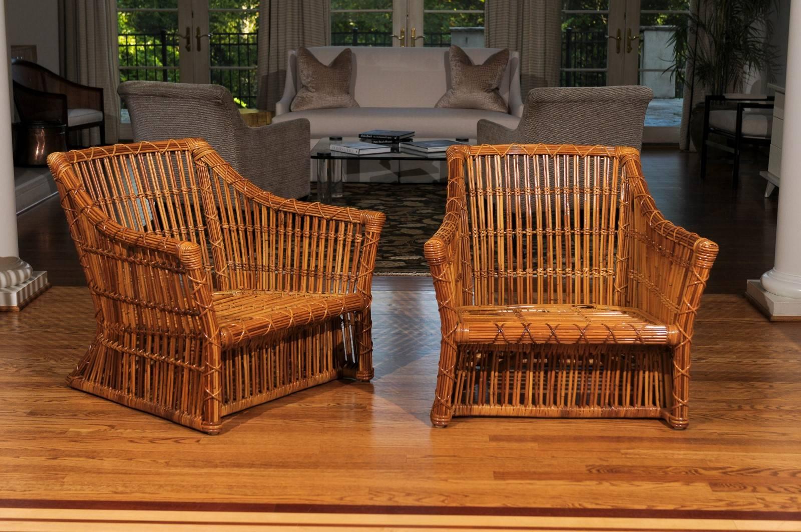 An absolutely stunning pair of vintage club chairs by McGuire, circa 1980. Examples from an extremely limited series. Expertly crafted hardwood frame construction veneered in pencil reed rattan. Incredible workmanship, detail and quality.