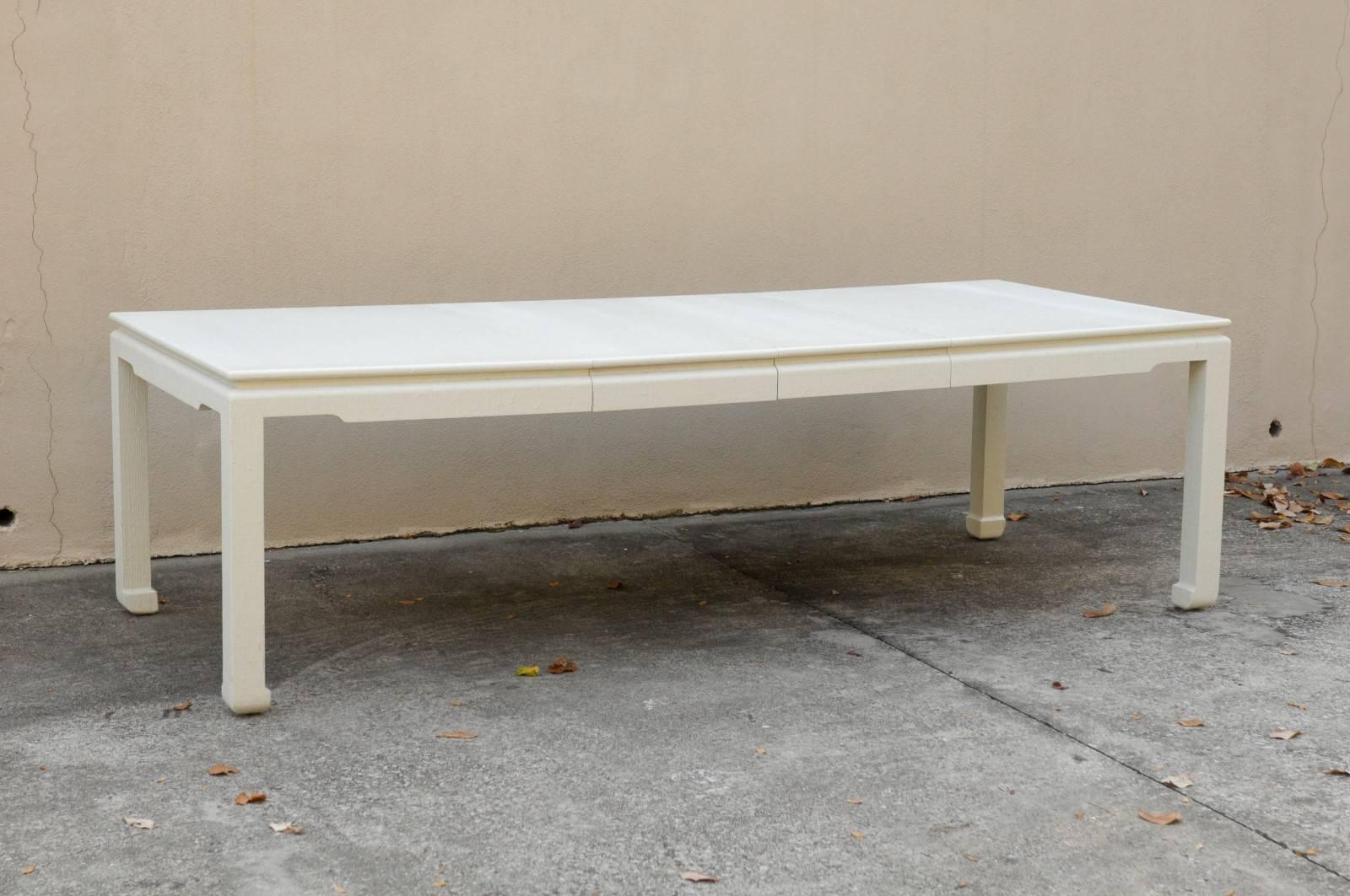 A stellar vintage dining table, circa 1970s. Handsome Parsons style form with subtle Asian detail at the apron and feet. Veneered in textured raffia and finished in cream lacquer. May also serve as a fabulous writing desk in its reduced form. The