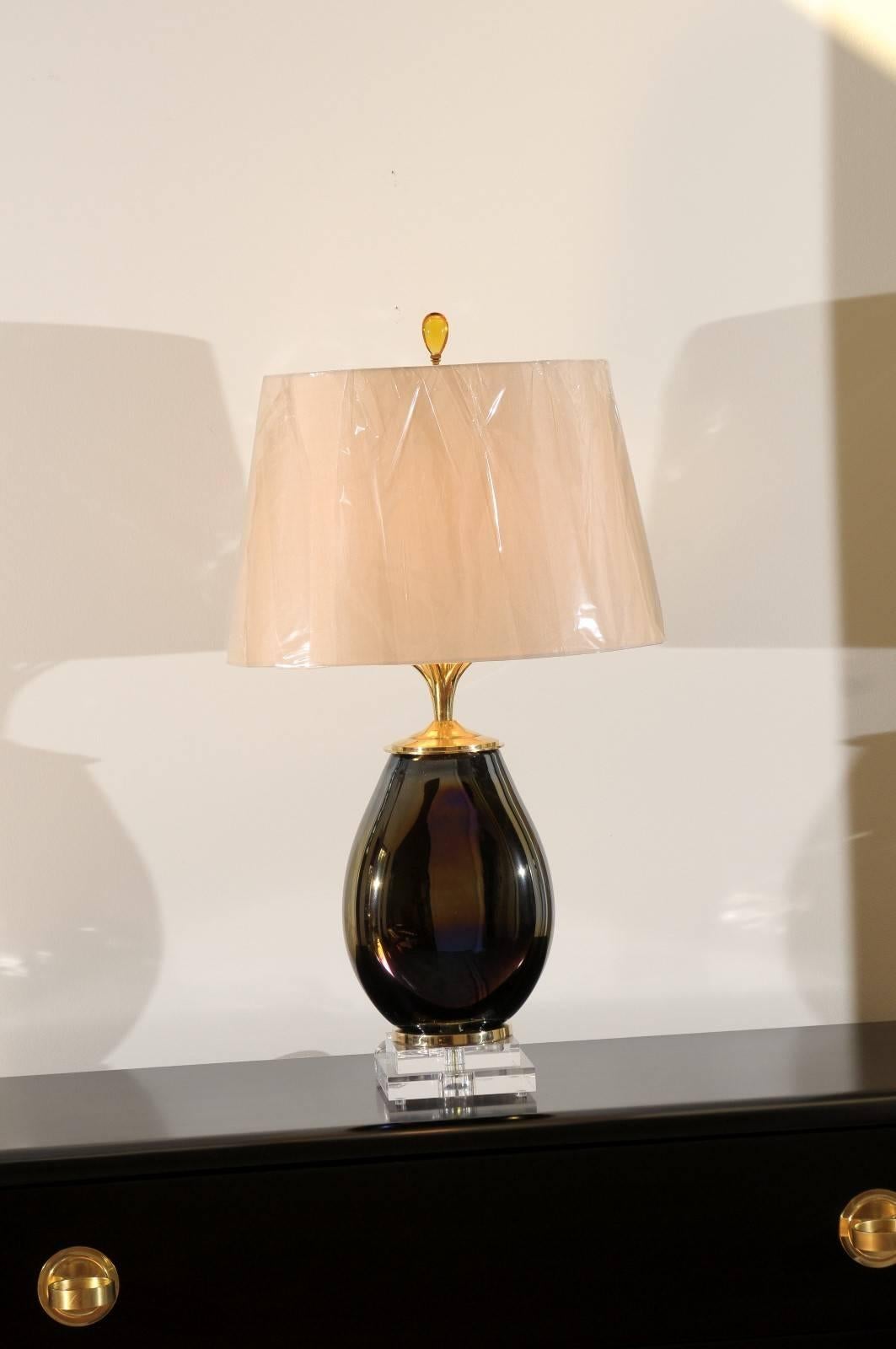 A stunning pair of blown glass vessels as custom lamps.  Heavy, thick blown smoke glass form with a subtle iridescent bronze cast.  Exquisite brass petal neck detail.  New custom three-step base comprised of museum quality Lucite and solid brass. 