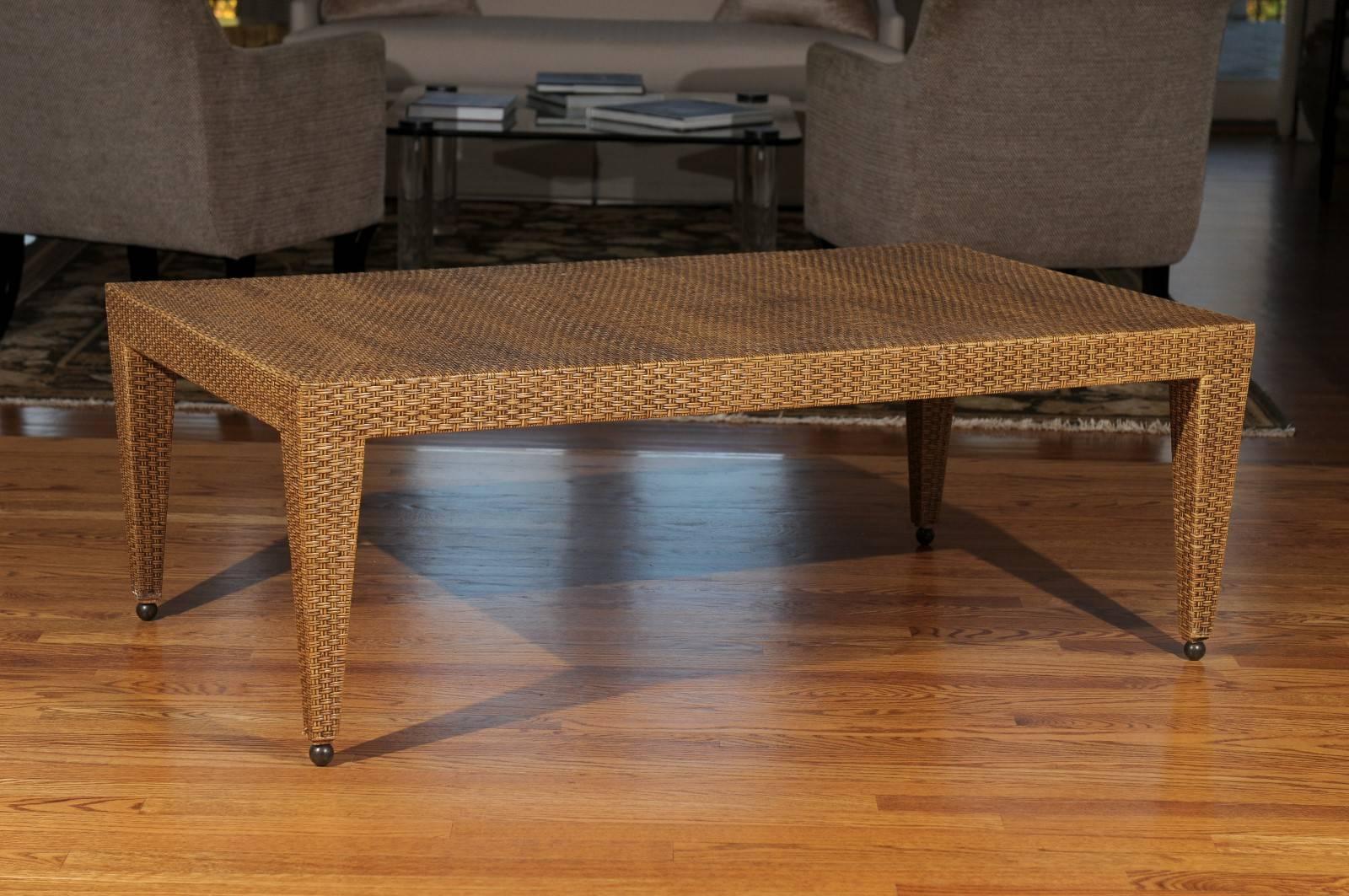 An exceptional vintage coffee table, circa 1985. Stout, expertly crafted hardwood form veneered in basketweave raffia-aged to absolute perfection! Solid nickel ball detail accent the legs. Fabulous warmth and texture. Sturdy enough to support