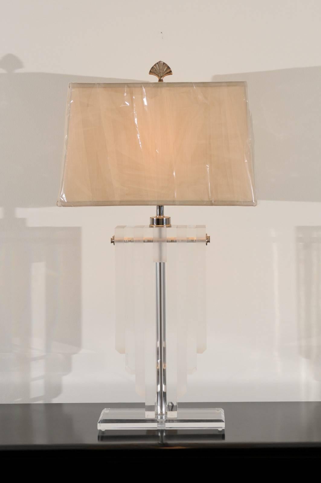 A stunning pair of vintage lamps, circa 1970. Thick Lucite slabs arranged in a dramatic shield form with nickel accents, atop a Lucite base. Heavy, beautifully crafted pieces. Exceptional jewelry! Excellent restored condition. Rewired using clear
