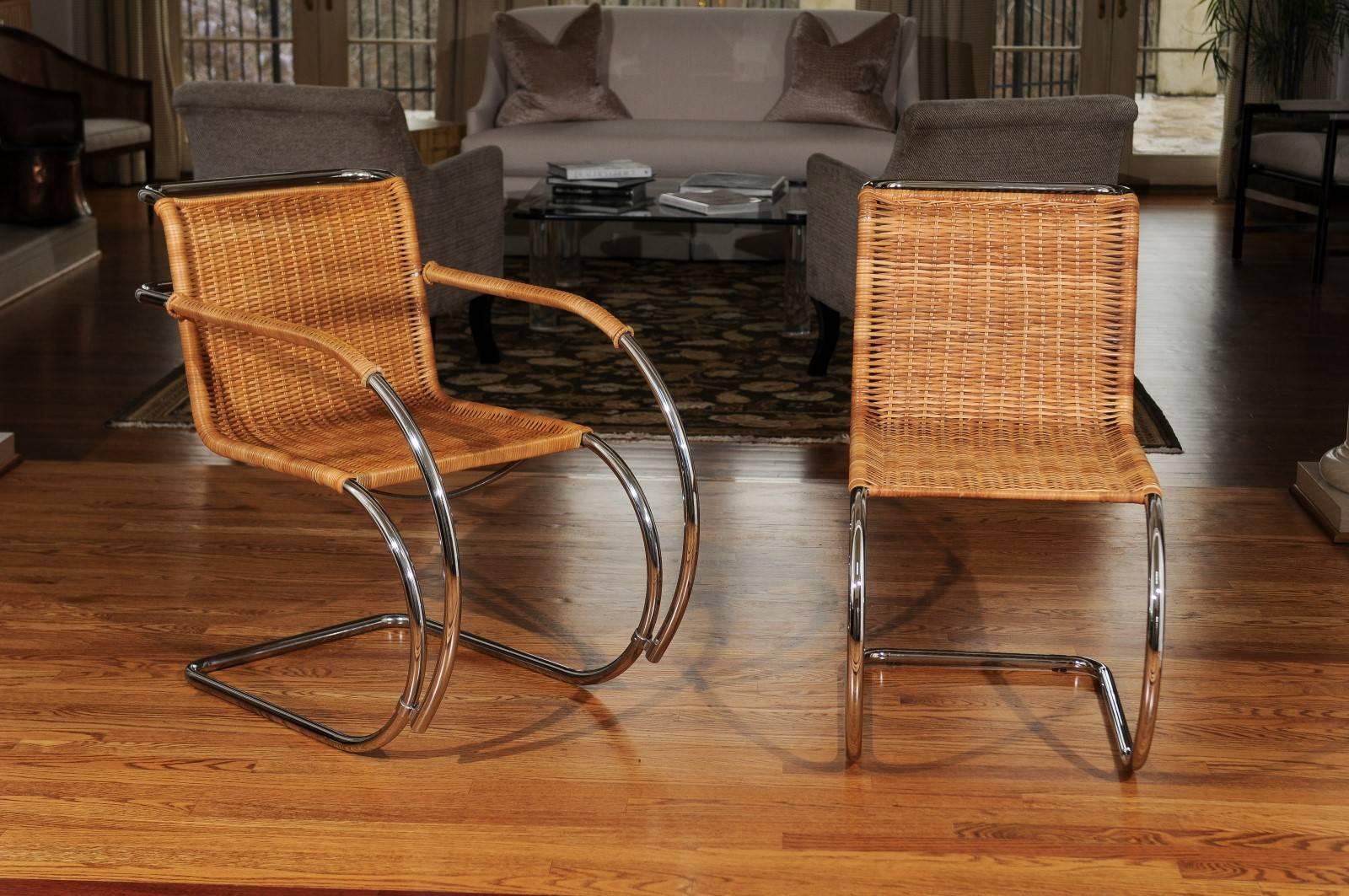 A fabulous set of eight (8) vintage wicker and chrome dining chairs in the style of Mies van der Rohe, circa 1970. Stellar quality and craftsmanship. This coveted cane version is always difficult to find and next to impossible to locate in