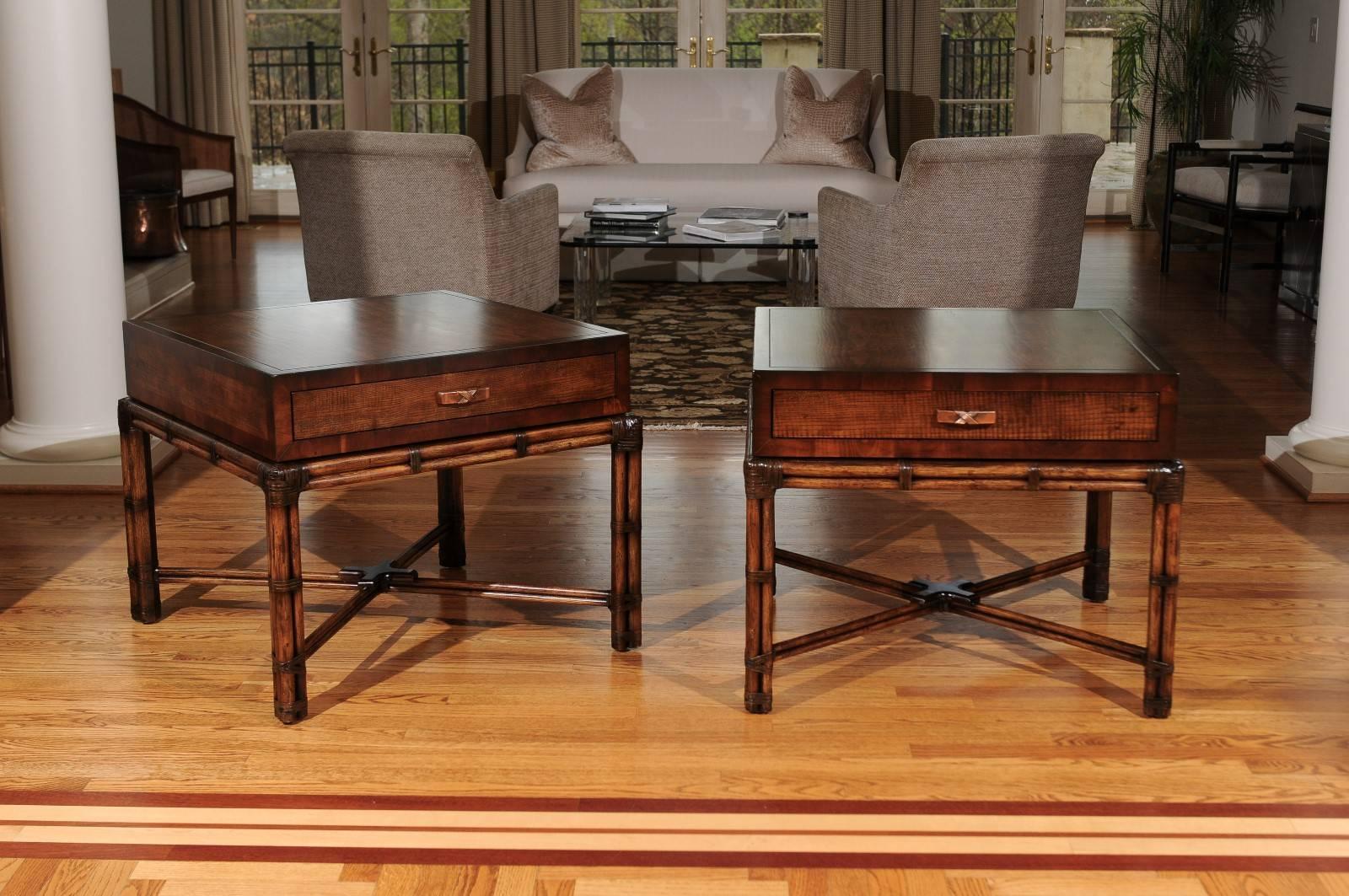 An exceptional pair of large-scale Campaign style end tables by Henredon, circa 1975. Lovely hardwood case with a single drawer atop handsome rattan base with leather accents. Fabulous quality and construction. Aged to absolute perfection. Stunning