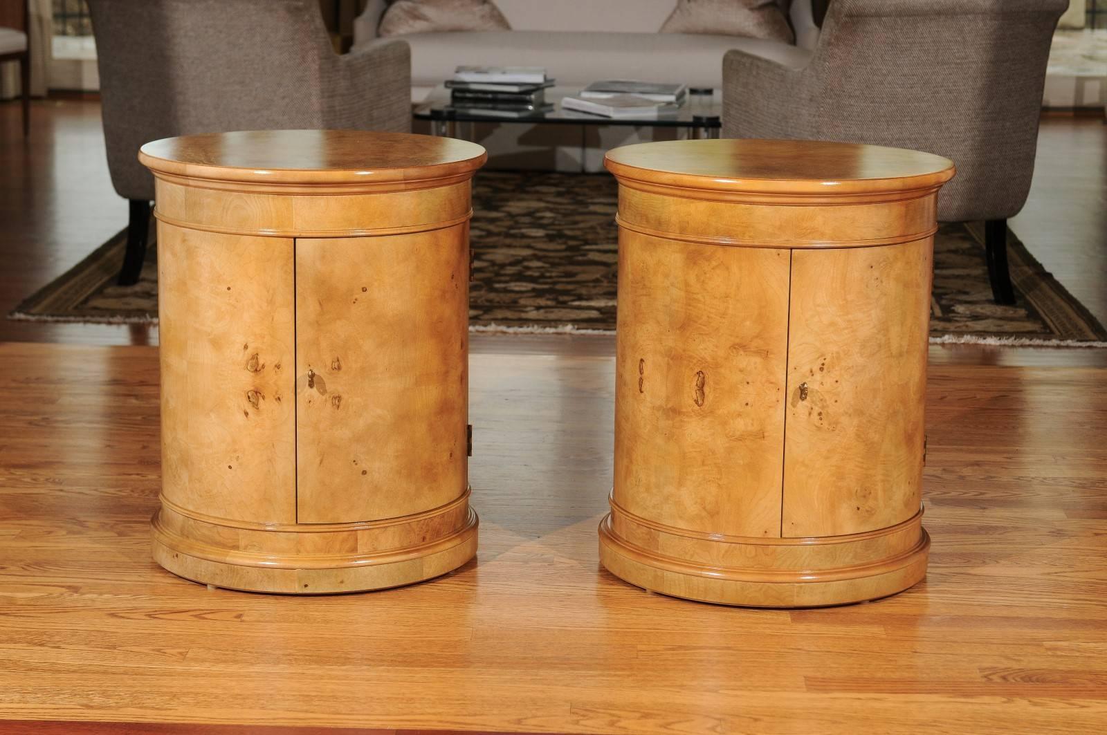 A fabulous restored pair of vintage drum tables by Henredon, circa 1980. Stout Ash construction veneered in bookmatched olivewood. The door opens to reveal an open compartment divided by a single adjustable shelf. Stylish and exquisitely made