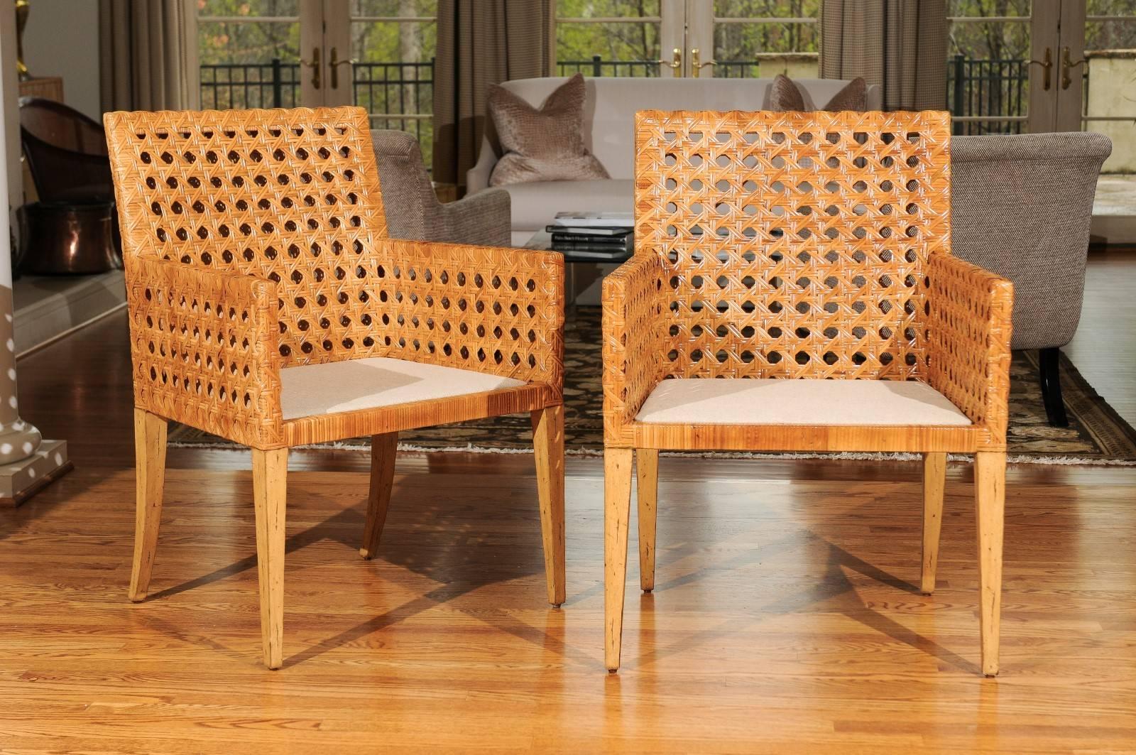 A exceptional pair large-scale arm or dining chairs, circa 1975. Stout hardwood frame construction painstakingly wrapped in double-sided cane. Fabulous quality and detail. Aged to absolute perfection. Exquisite jewelry! Excellent restored condition.