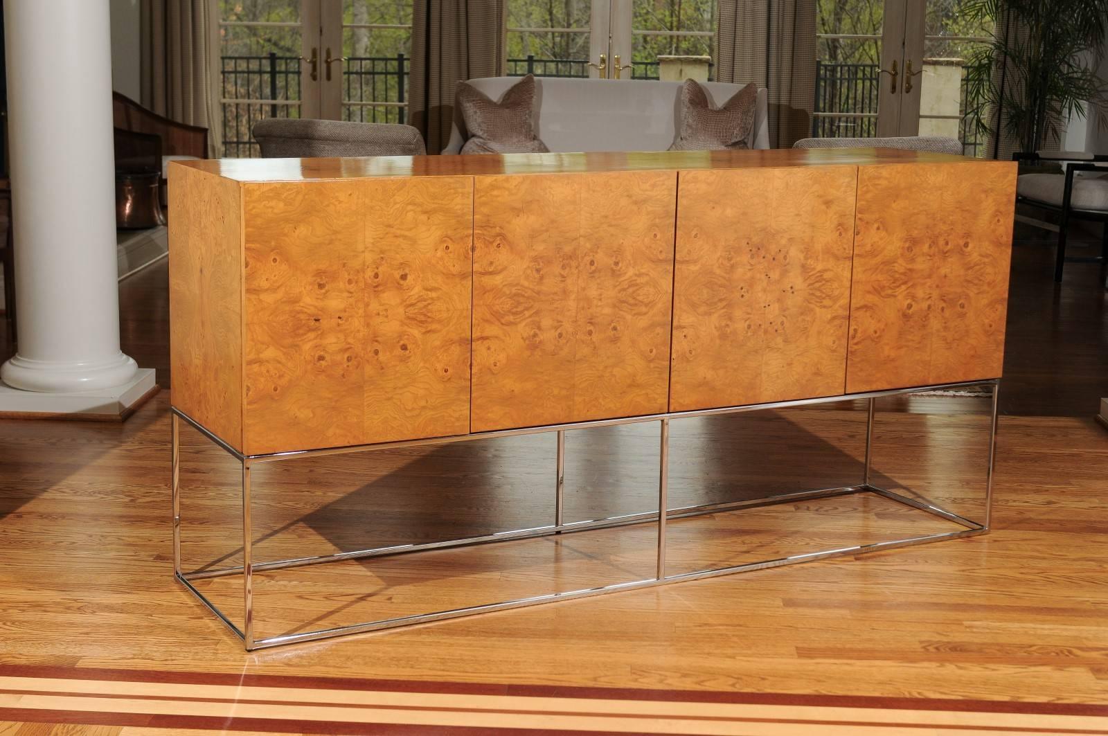 A stellar buffet or credenza by Milo Baughman for Thayer Coggin, circa 1975. Exquisite bookmatched olivewood veneer over solid ash case construction atop an elegant chrome base. Tremendous craftsmanship and attention to detail. This particular