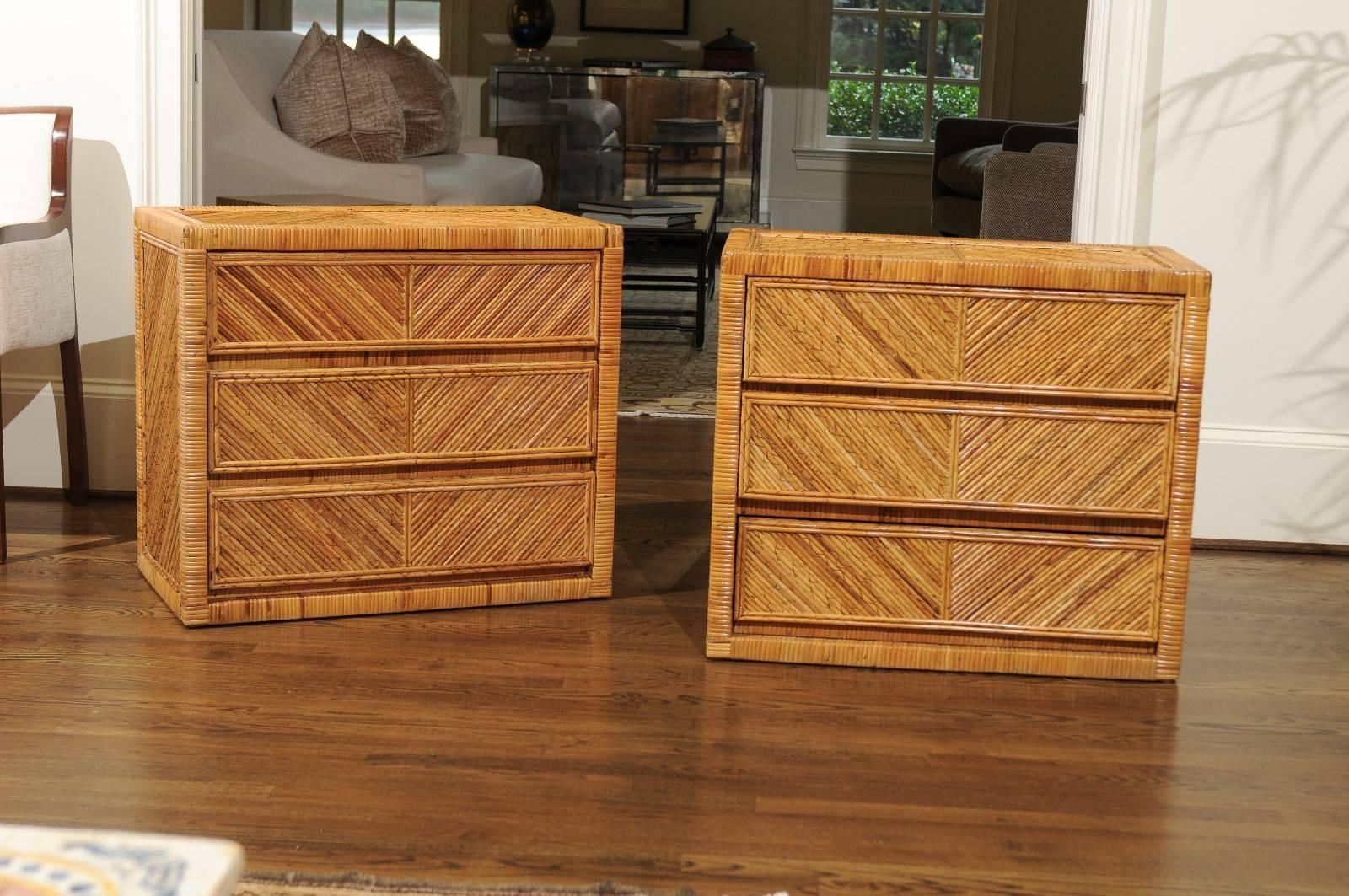 An exquisite pair of vintage small chests, circa 1975. Exceptionally crafted solid hardwood case construction, painstakingly veneered in diagonally applied reed bamboo with rattan cane accents. Completely finished on all sides. Stellar design and