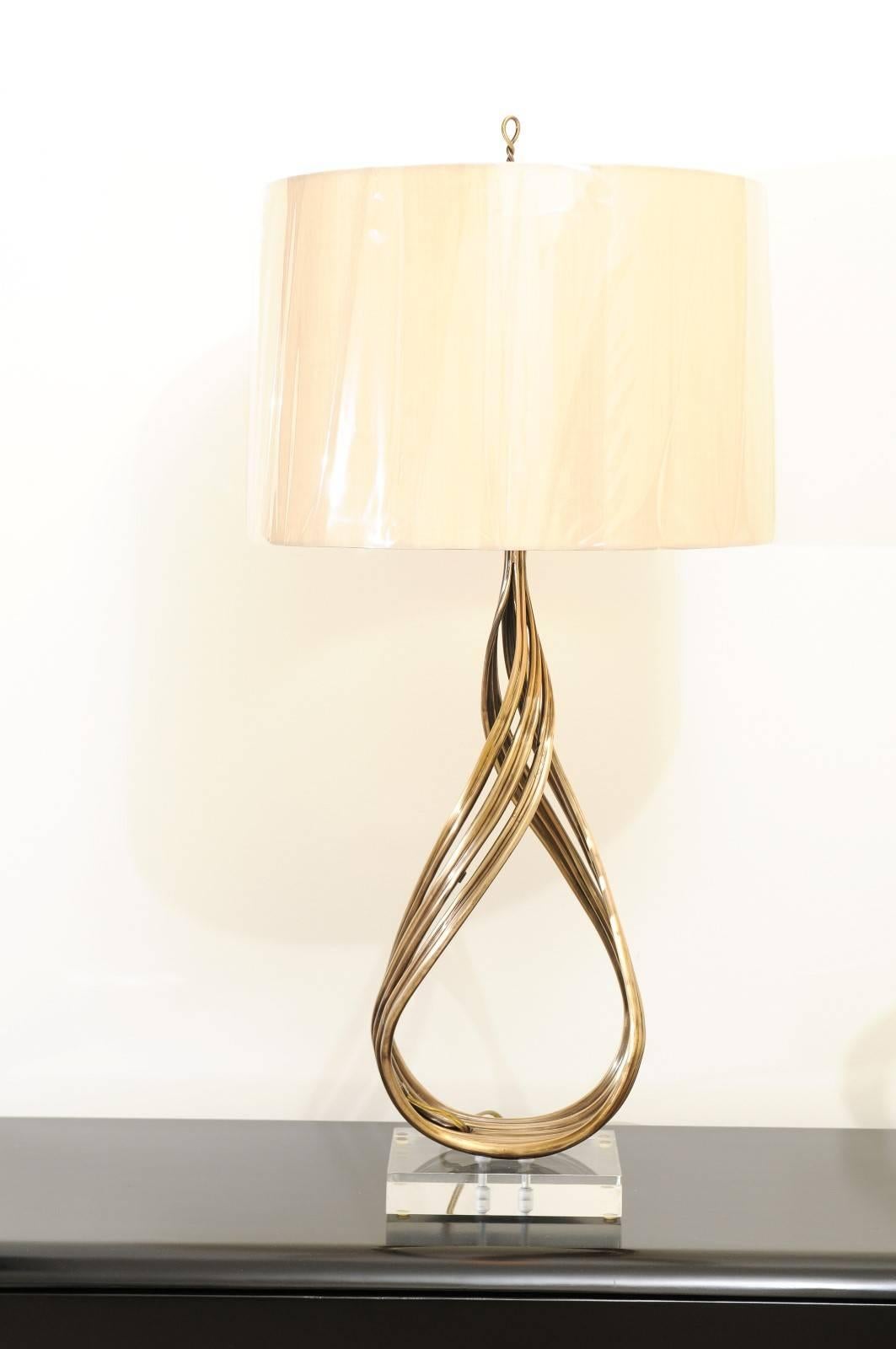 A fabulous restored pair of large-scale lamps from a difficult to find series produced by Chapman, circa 1993. The stunning twisted solid brass form evokes a flame, mounted atop a chunky Lucite plinth. One of the most coveted designs in the Chapman