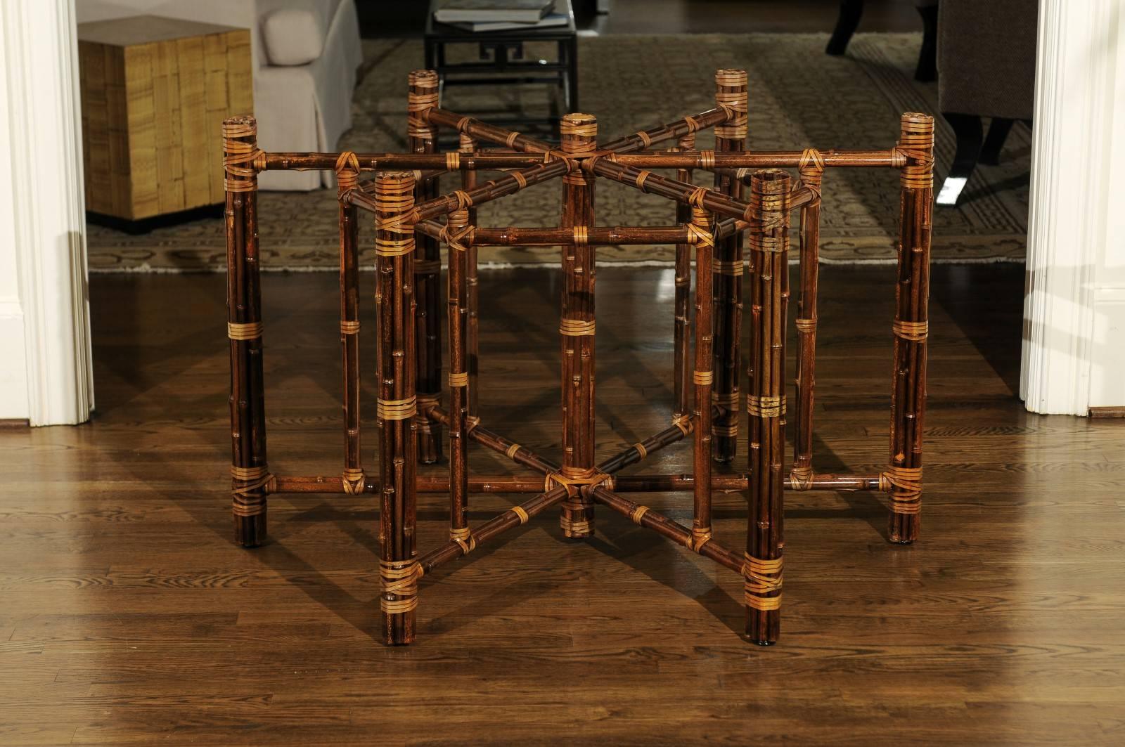 Une exceptionnelle table circulaire de salle à manger ou de centre par McGuire, vers 1990. La base de la table a un diamètre de 44 pouces.  Structure robuste en acier lourd plaquée en bambou ; détails en cuir dans le style emblématique de McGuire.