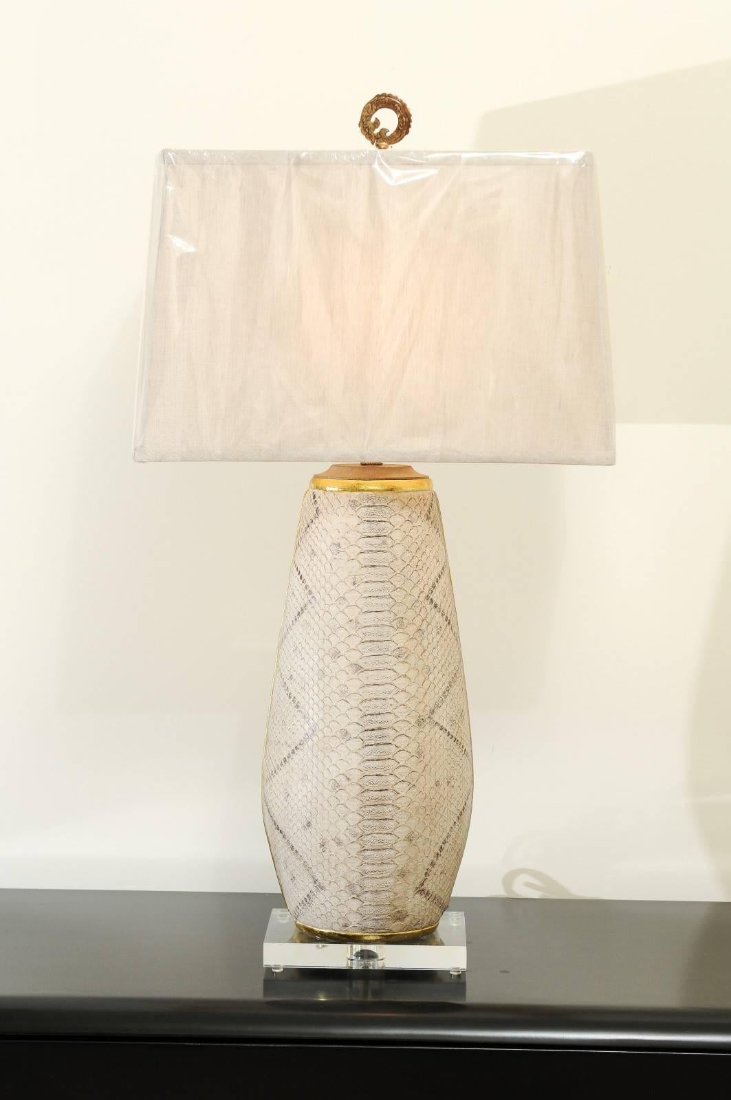 A fabulous pair of handmade faux-snakeskin vessels as custom-made lamps. Handsome wood form, leather wrapped and hand-painted to portray the look of snakeskin. Gold leaf accents. Stunning scale, color and texture. Built using only components of the