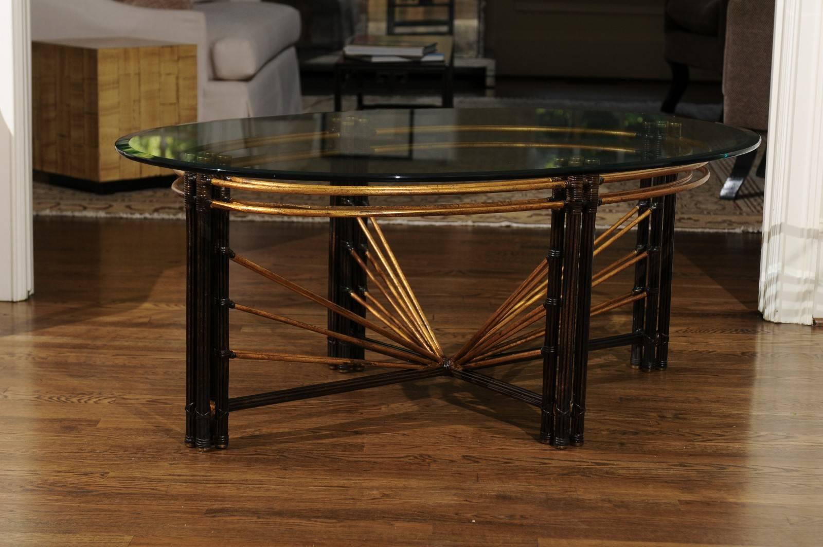 Une table basse d'une beauté étonnante, datant de 1970. Construction en acier lourd, conçue et peinte pour ressembler à du bambou. De superbes reflets dorés avec des accents en laiton massif. Plateau en verre épais à bord biseauté. Une qualité et un