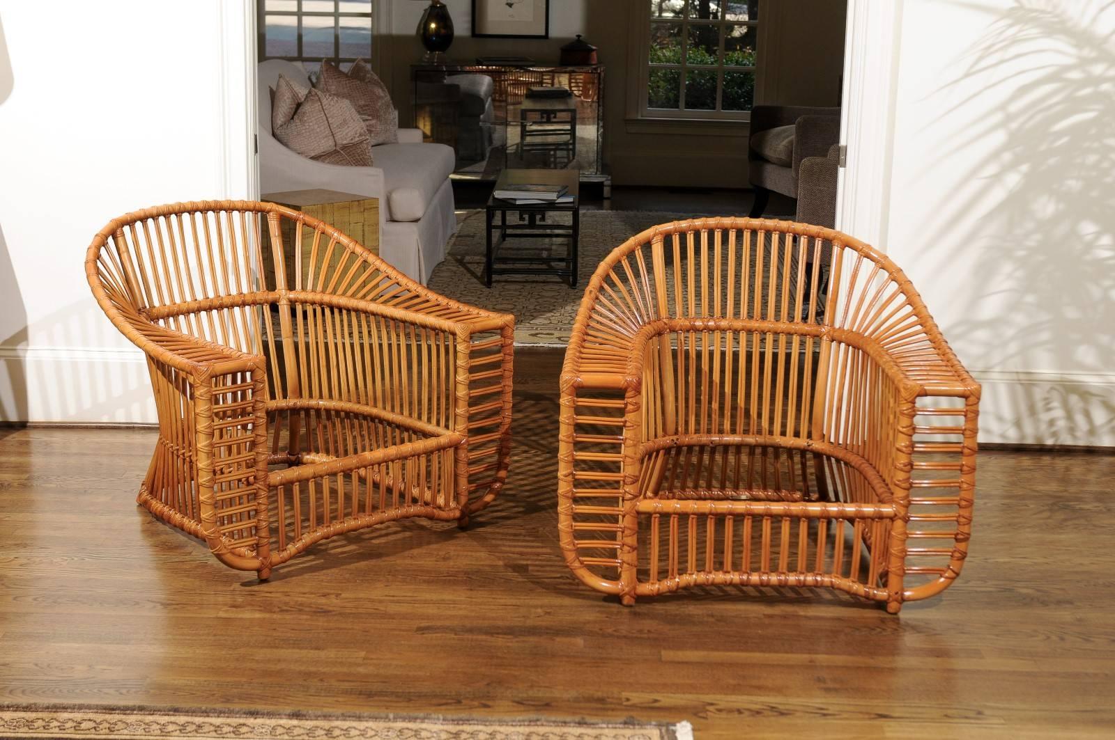 An exquisite and unique pair of lounge or club chairs by the esteemed Henry Olko for his Willow and Reed firm, circa 1979.  These rare chairs are from the Tiara series. Stout and sturdy rattan and hardwood construction with exacting detail. These