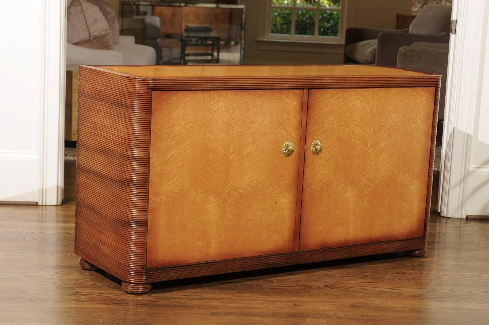 A stunning, unique restored cabinet by Baker Furniture, circa 1980. Expertly constructed reed bamboo case construction with doors, top and back veneered in bookmatched Birdseye Maple. Custom butter-burst lacquer finish in the style occasionally
