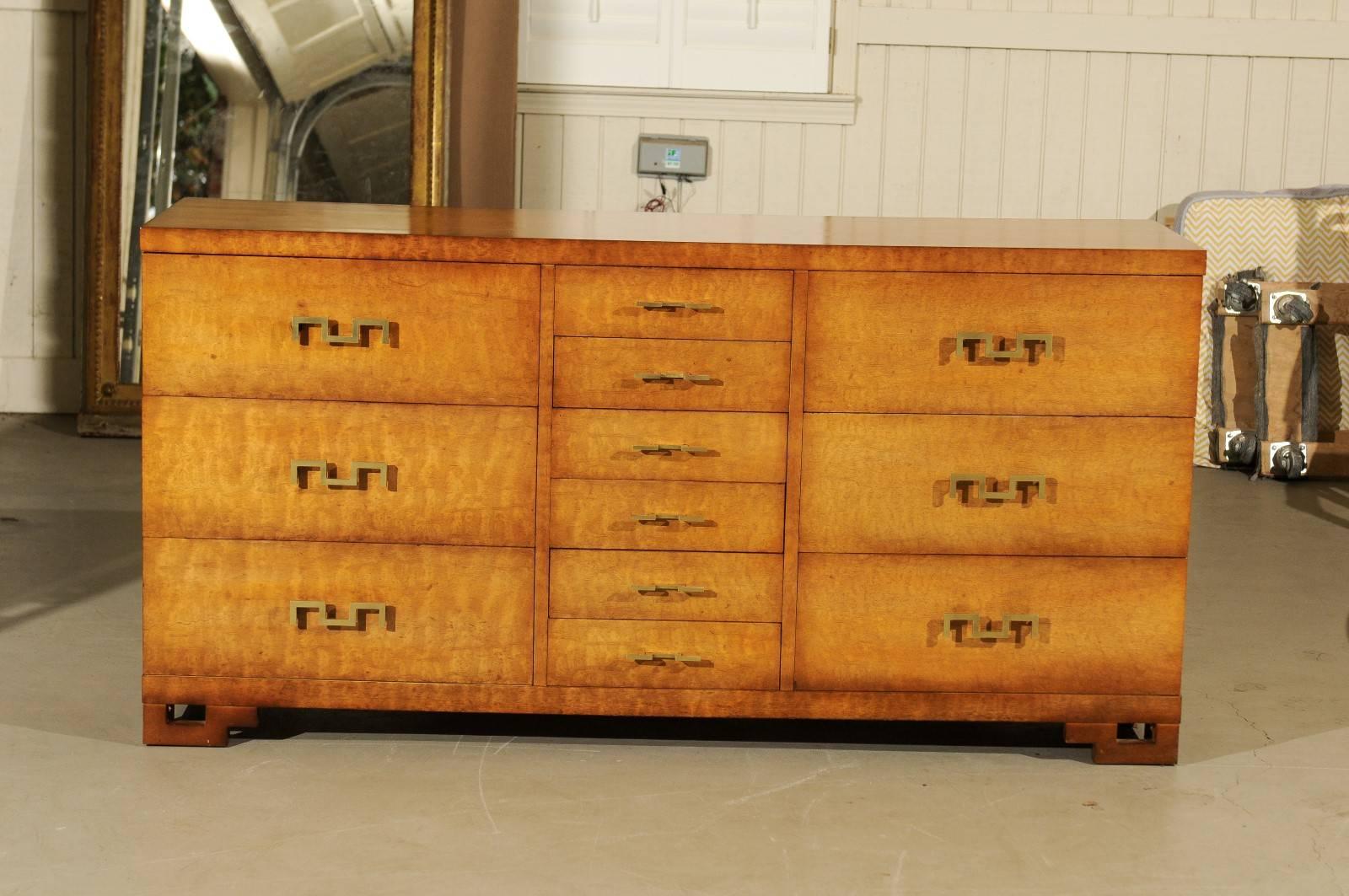 A stunning 12-drawer chest by John Stuart, circa 1960. Stout, expertly constructed case executed in exotic African Mahogany, atop wonderful Greek key feet. Heavy, stylish solid brass Greek key hardware mark the drawers. Aged to absolute perfection.