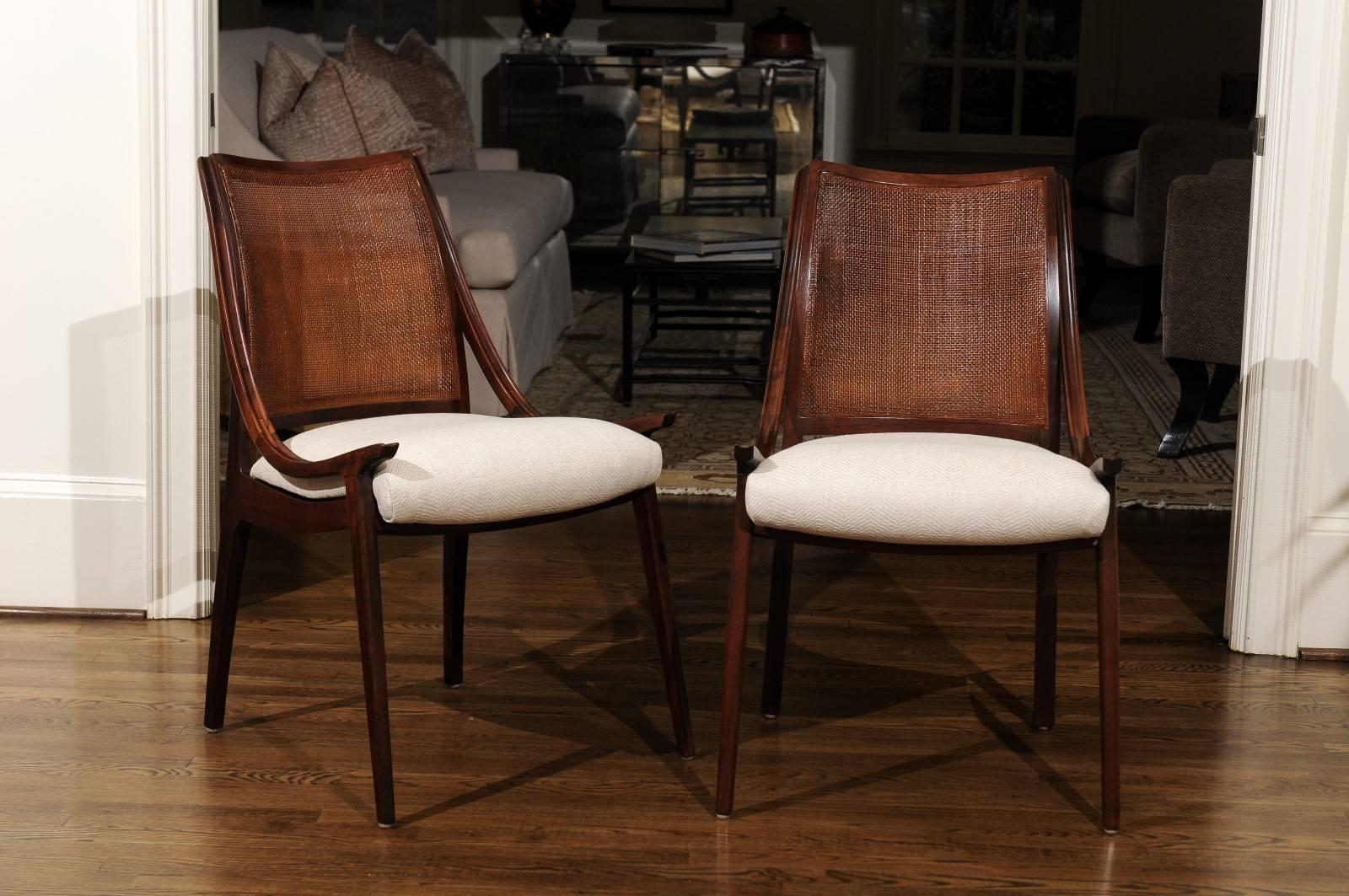 The rarest of the rare: An exceptional, meticulously restored set of eight (8) cane back dining chairs by John Kapel for Glenn of California, circa 1960. Expertly crafted solid Walnut construction with stellar lines and detail. Delicate cane panel