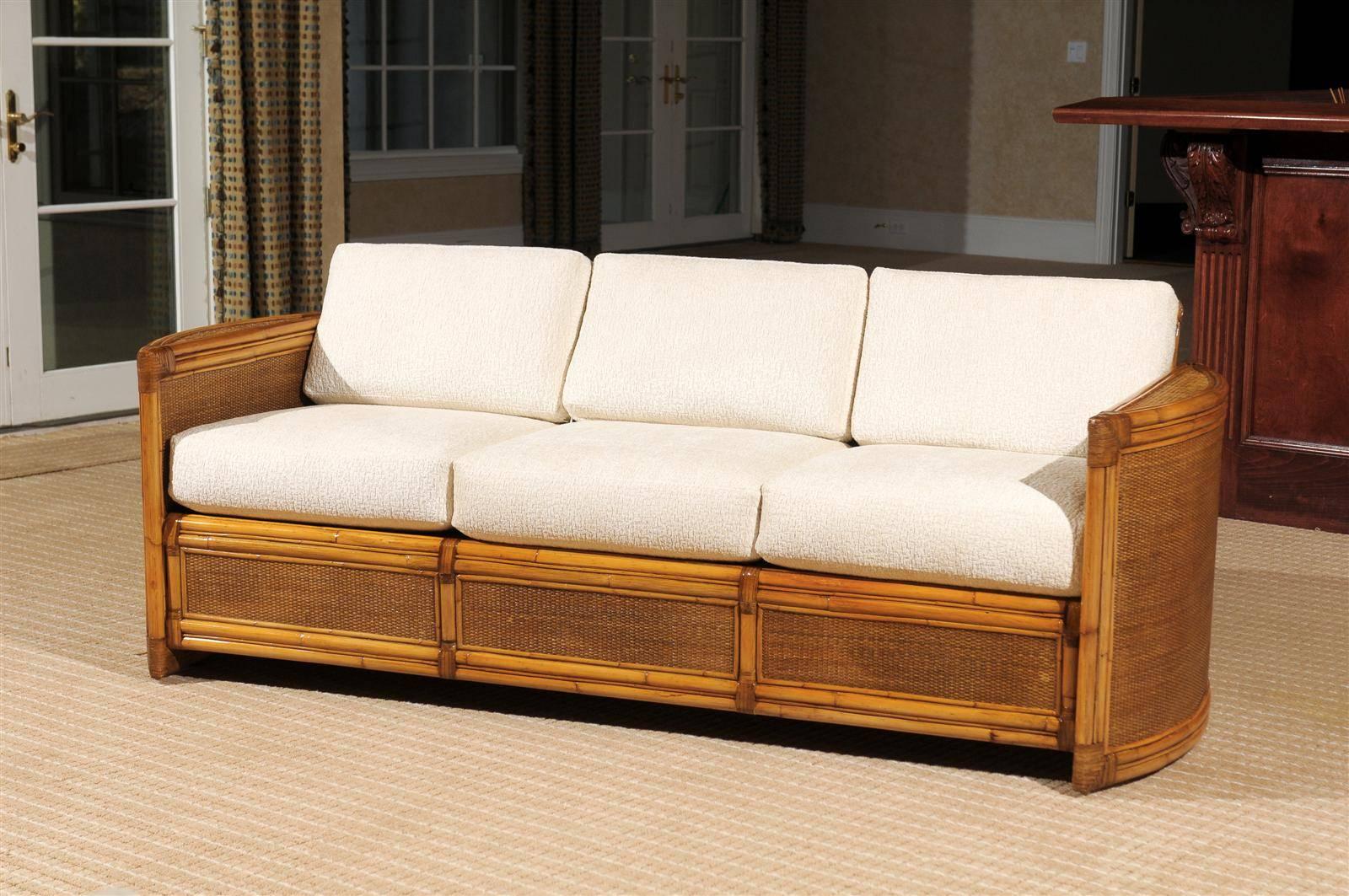A beautiful large-scale vintage sofa, circa 1980. Stout rattan and hardwood construction with raffia panel accents and leather detail.  Excellent support and comfort. Exceptional design and craftsmanship. A wonderful way to bring warmth and texture
