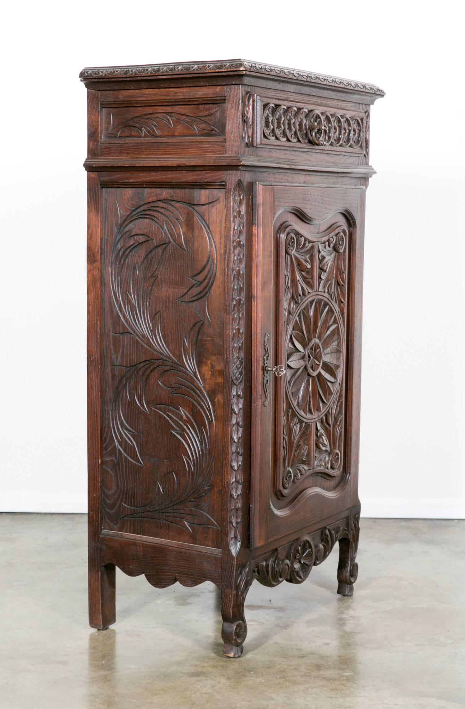 Antique Country French Louis XV style confiturier (jam holder) from Normandie, circa 1880s. Handcrafted of oak with some of the finest hand-carved details. Two interior shelves. Carved apron resting on short raised cabriole legs ending in scrolled