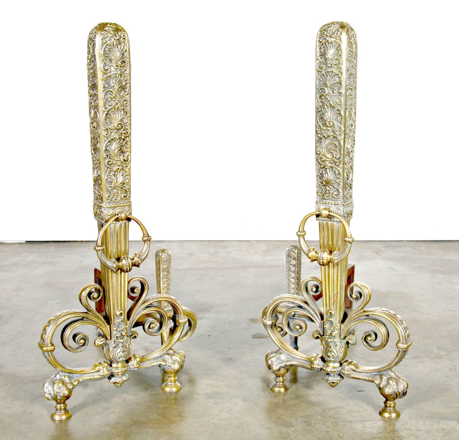 An exceptional pair of tall patinated brass and wrought iron andirons ornamented with stylized interlaced scrolls, having original ornamented circular handles, attributed to Tiffany Studios, circa 1890s. These rare and collectible andirons are