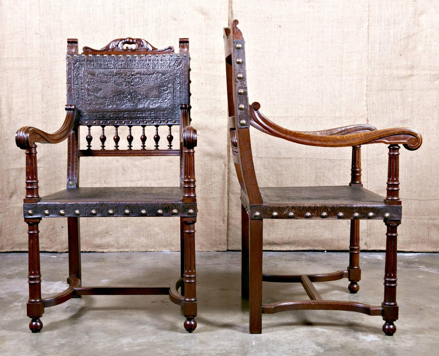 Pair of mid-19th century French Renaissance Henri II fauteuils from a chateau in the Loire valley, having hand-carved walnut frames with original hand tooled leather seats and backs with brass nailhead trim. Chairs are solid and very sturdy and