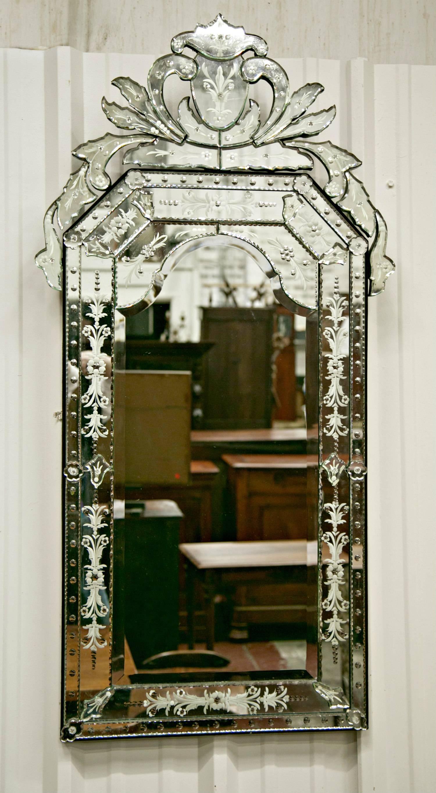 A fine 20th century Venetian mirror with original bevelled mirror plates and engraved mirrored border sections secured with pins shaped as florets, each mirror with pierced glass pediment top.
  