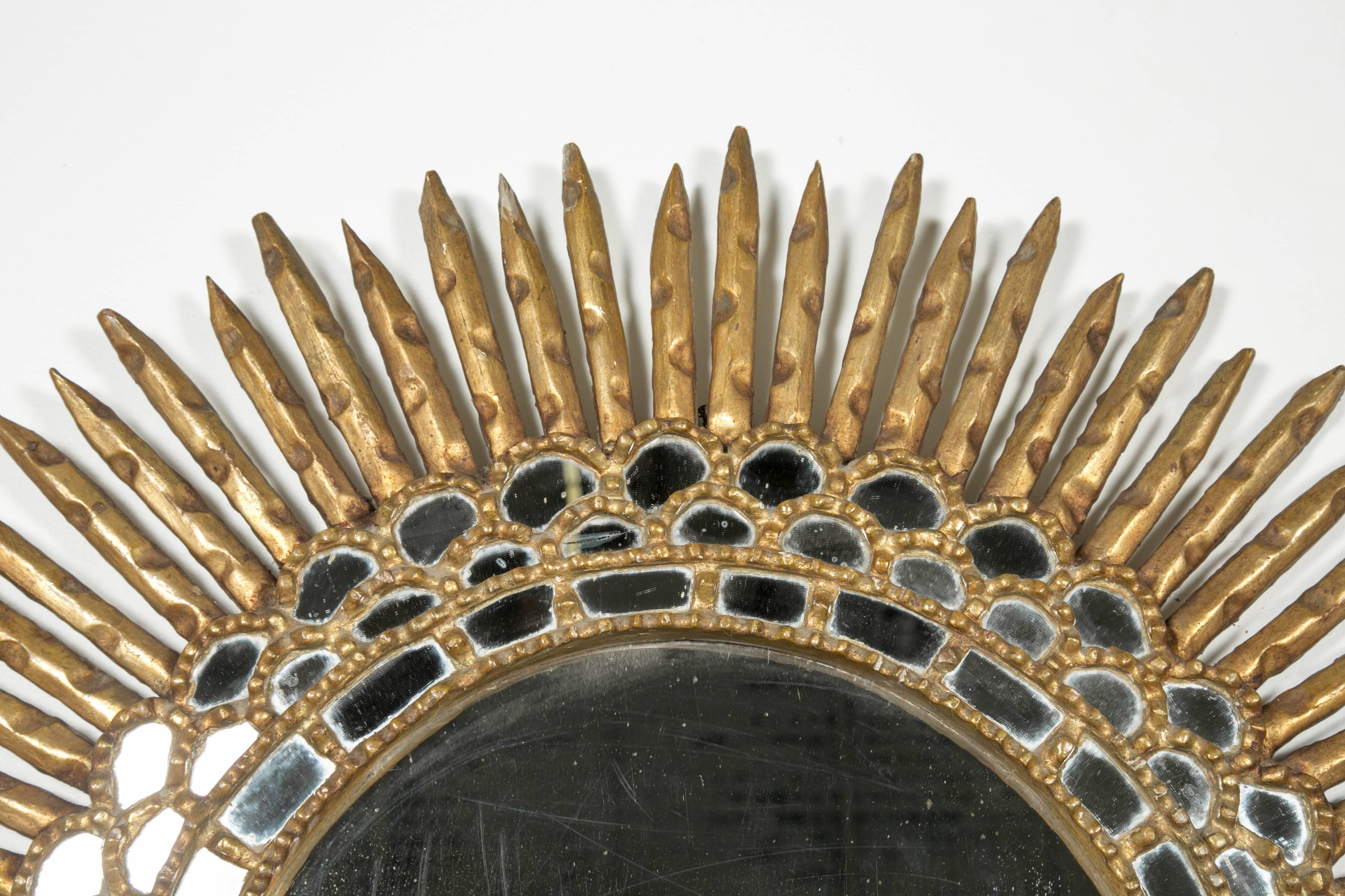 A Spanish gilt and carved wood sunburst mirror with mirror insets, circa early 1900s. All original.

Dimensions:
Total size is 34.5 inches diameter
Mirror is 14.5