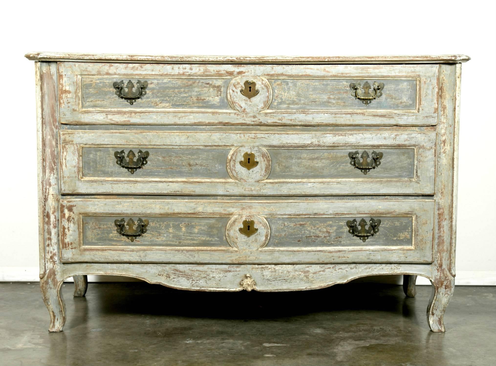 Lovely 18th century French Louis XV period commode with serpentine front, three carved drawers, original hardware and paneled sides. Shaped apron resting on short cabriole legs. Having a wonderfully distressed painted finish with the top having