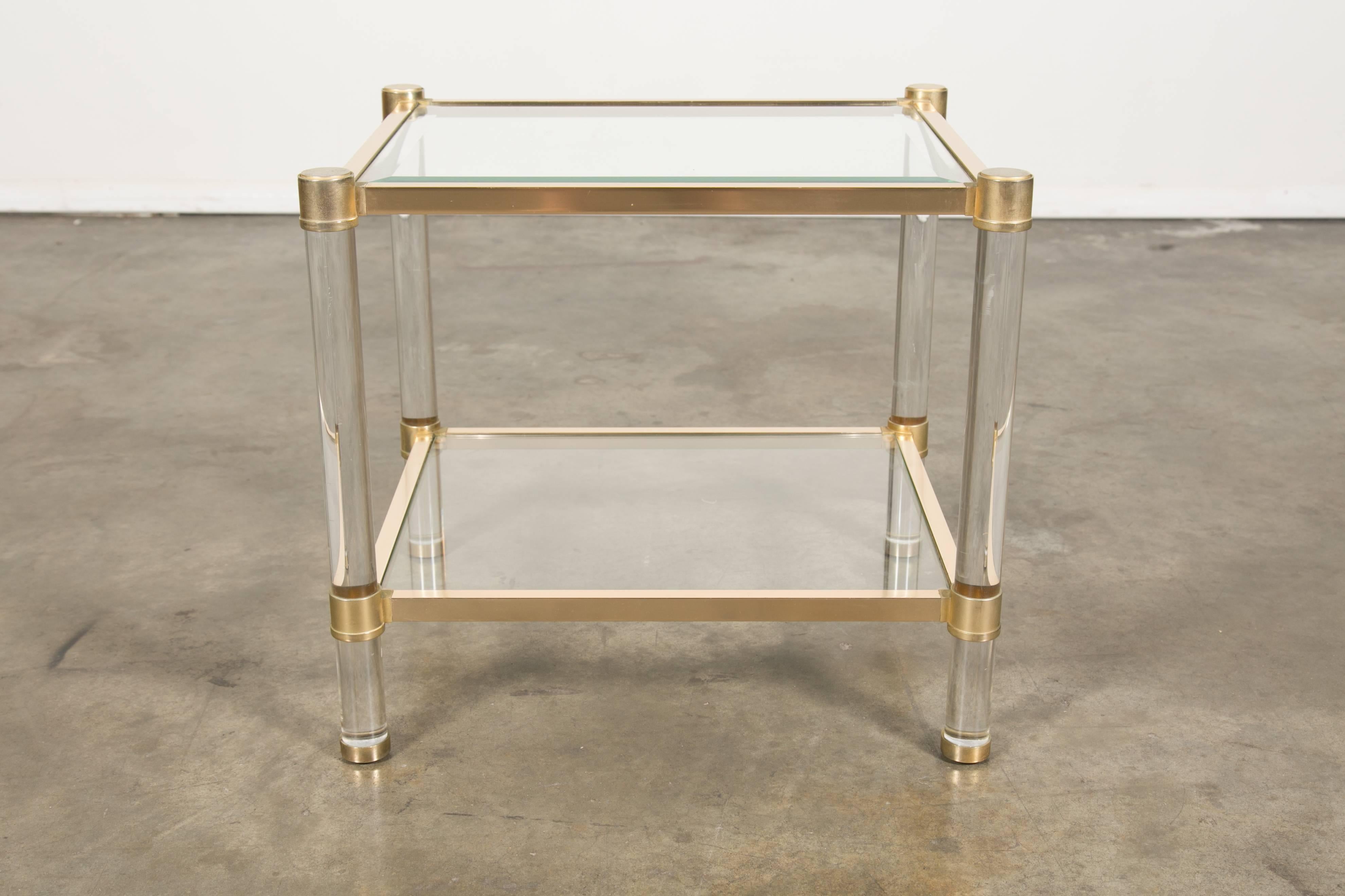 French two-tier Lucite and brass rectangular side table with beveled glass top and lower glass shelf. circa 1970s. Attributed to the famous Paris atelier Maison Jansen, this table looks beautiful mixed with antiques or contemporary decor. It's a
