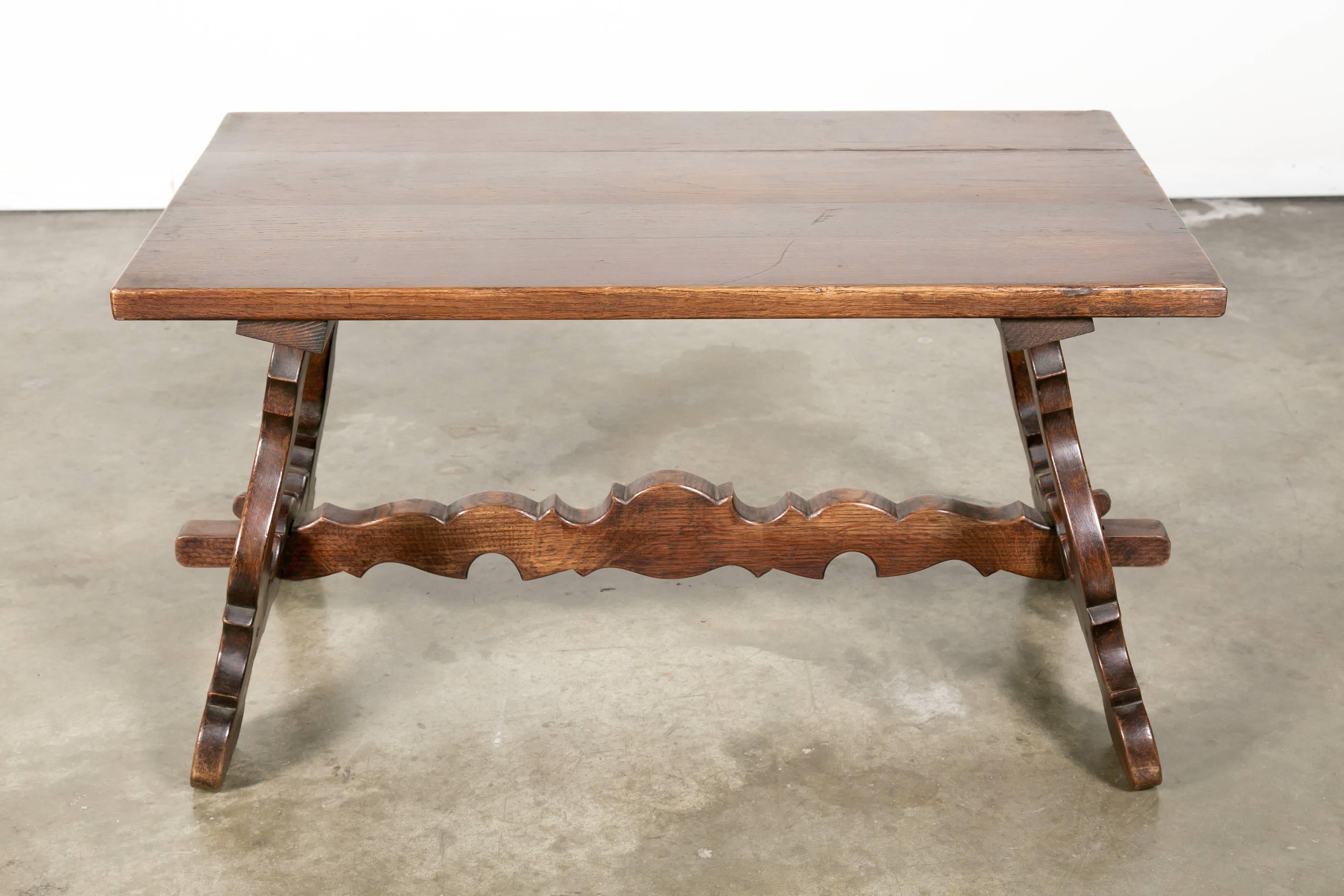 A charming Spanish Colonial style coffee table constructed of solid oak. Graceful sculpted 