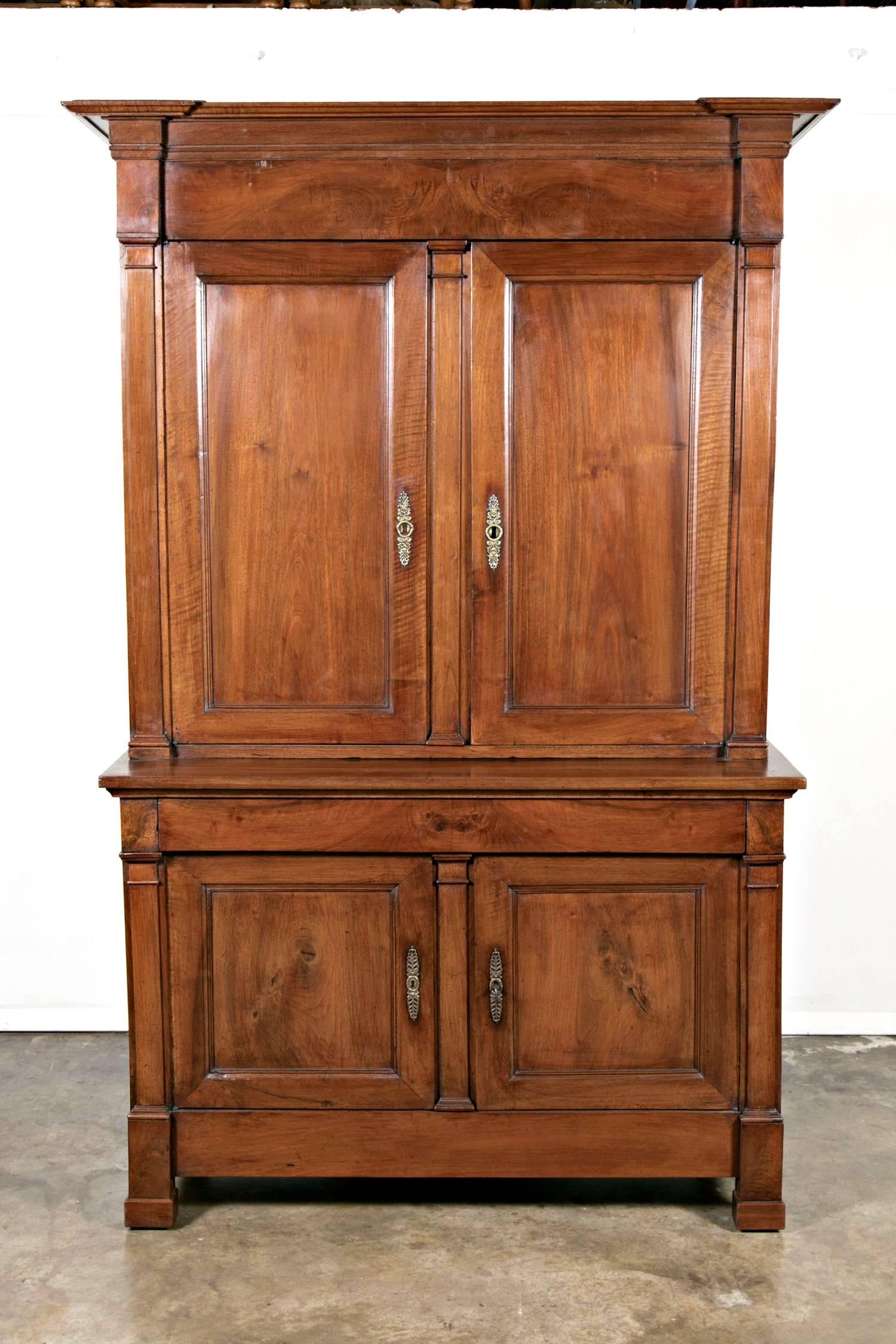 Antique French Directoire period buffet deux corps handcrafted of solid walnut by talented artisans near Bordeaux. Having an upper cabinet with paneled doors flanked by flat pilaster columns that open to reveal three interior shelves, sitting atop a