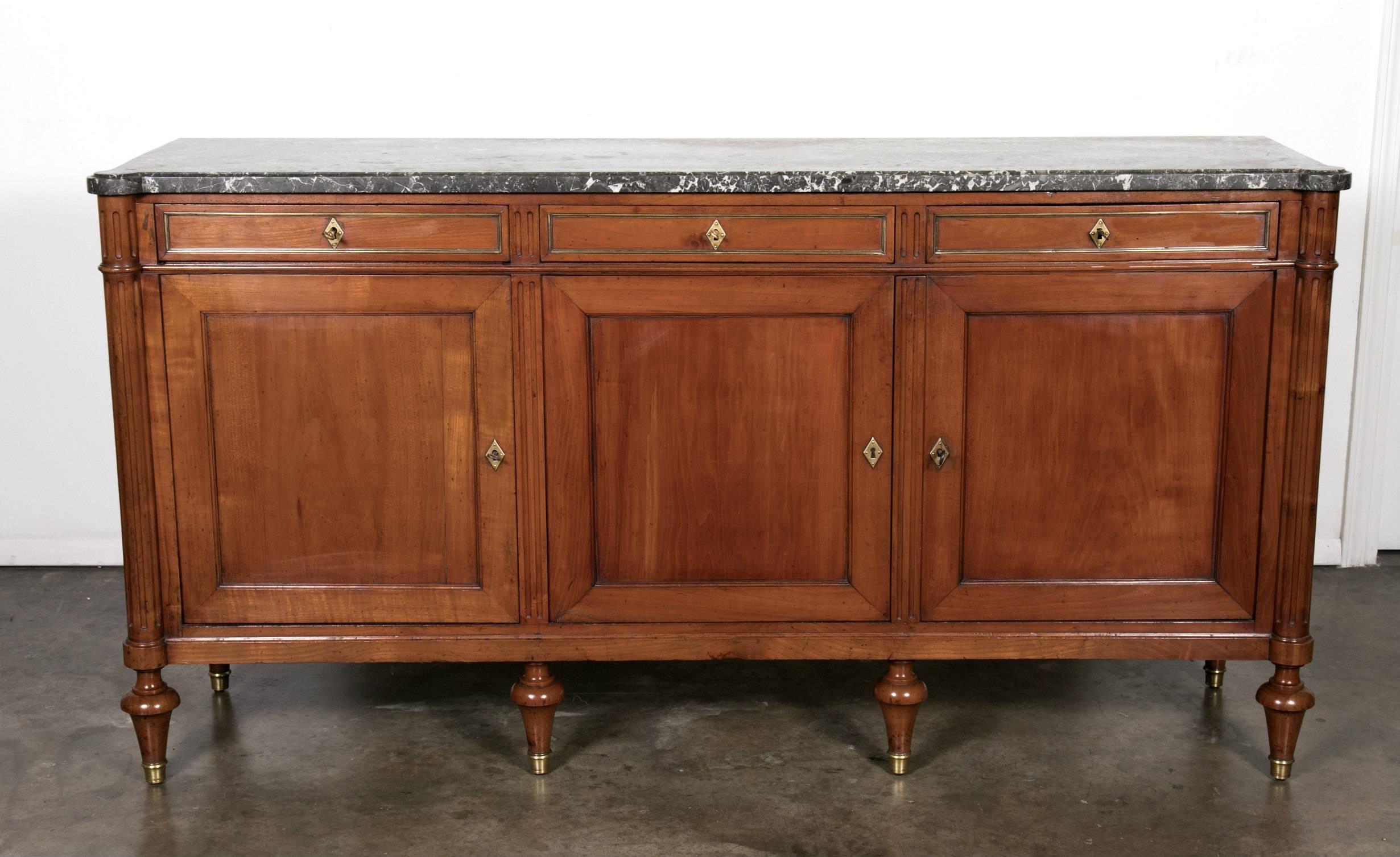A 19th century Louis XVI style walnut enfilade with Saint Anne marble-top in excellent original condition, retaining its beautiful rich, original color and patina with a fresh French polish that allows the wood to shine. Three drawers over three