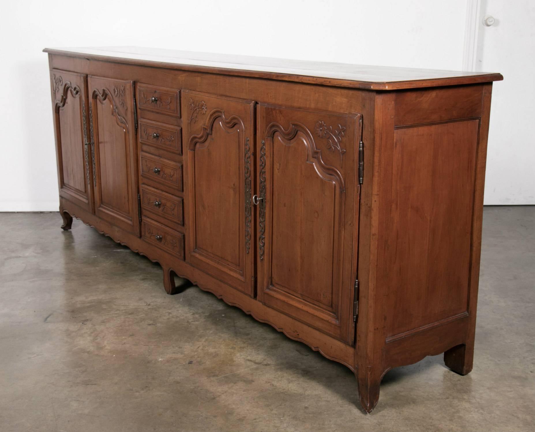 Grand French Country enfilade handcrafted in the early 1800s from solid cherrywood by talented artisans from the Brittany region located in northwest France. Spanning eight feet four and a half inches, this splendid Louis XV style enfilade buffet