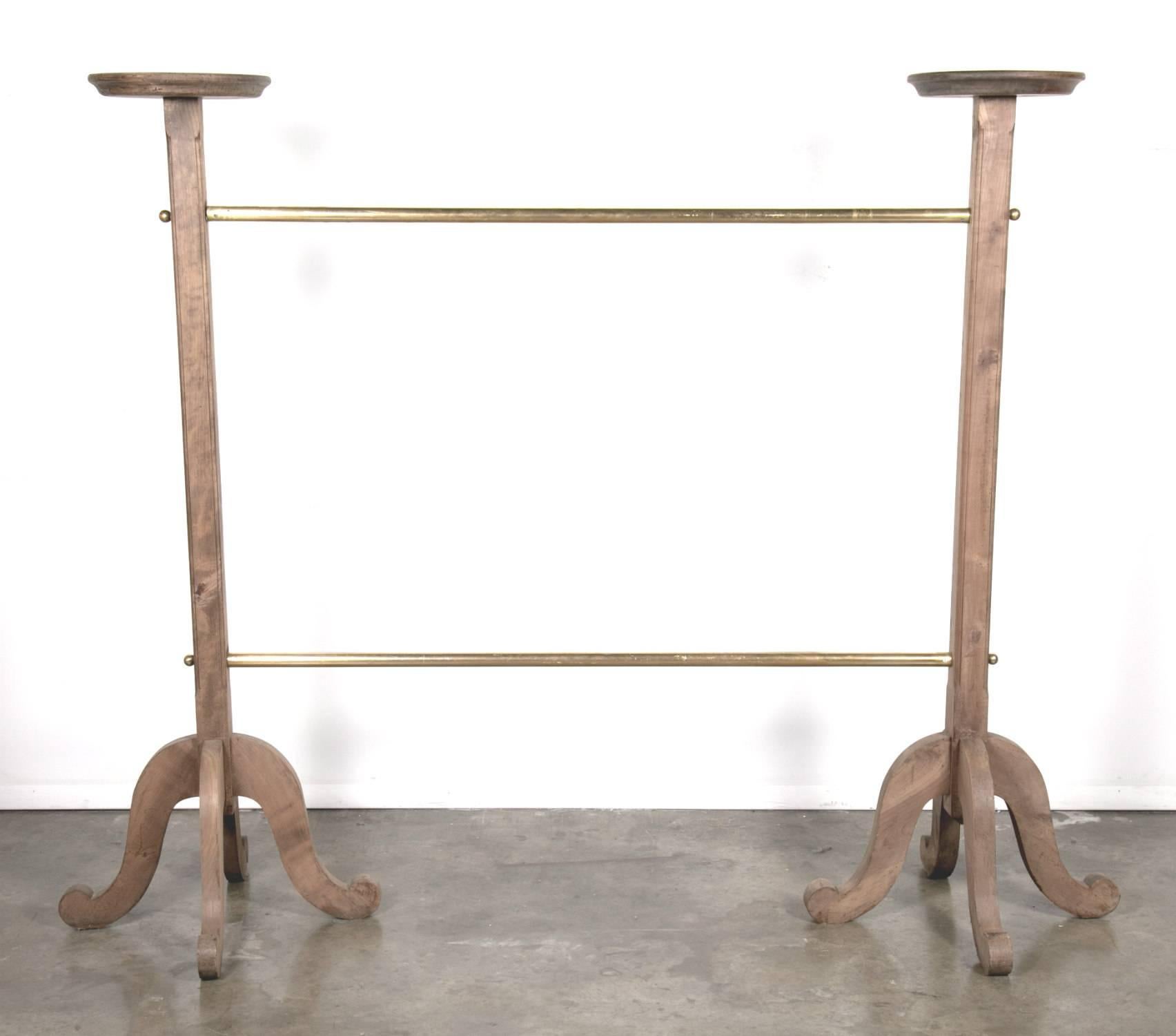 Fabulous and sophisticated 1930s two-tier polished old French brass garment rack, featuring bleached oak pedestal column bases from the famous French department store chain Galeries Lafayette in Paris. Clothing racks like these are a very rare