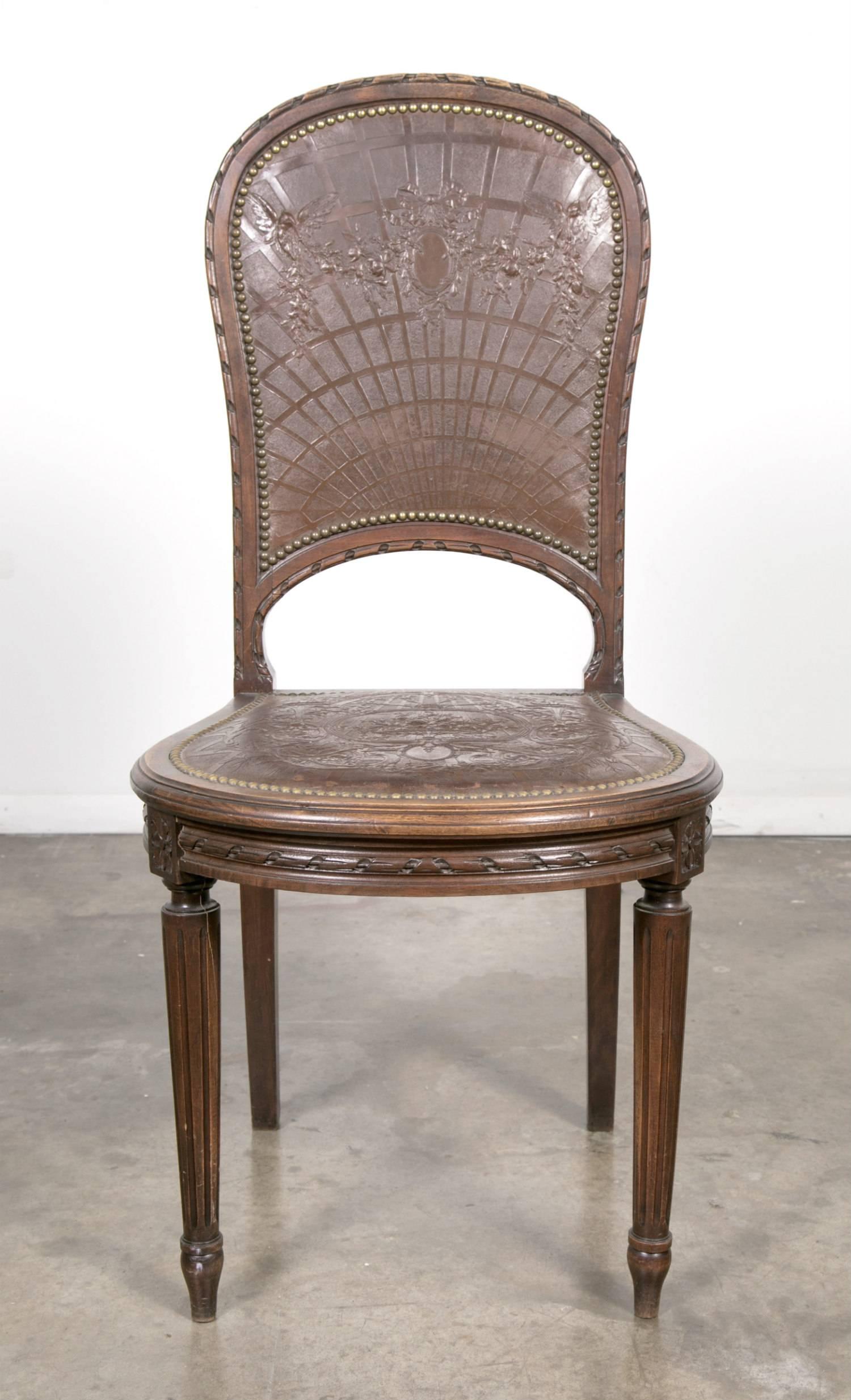 Elegant set of six French Louis XVI style tooled leather dining chairs handcrafted in Paris, having beautifully crafted solid oak frames and original tooled leather seats and backs with nailhead trim, circa 1880s. The intricate tooled leather design