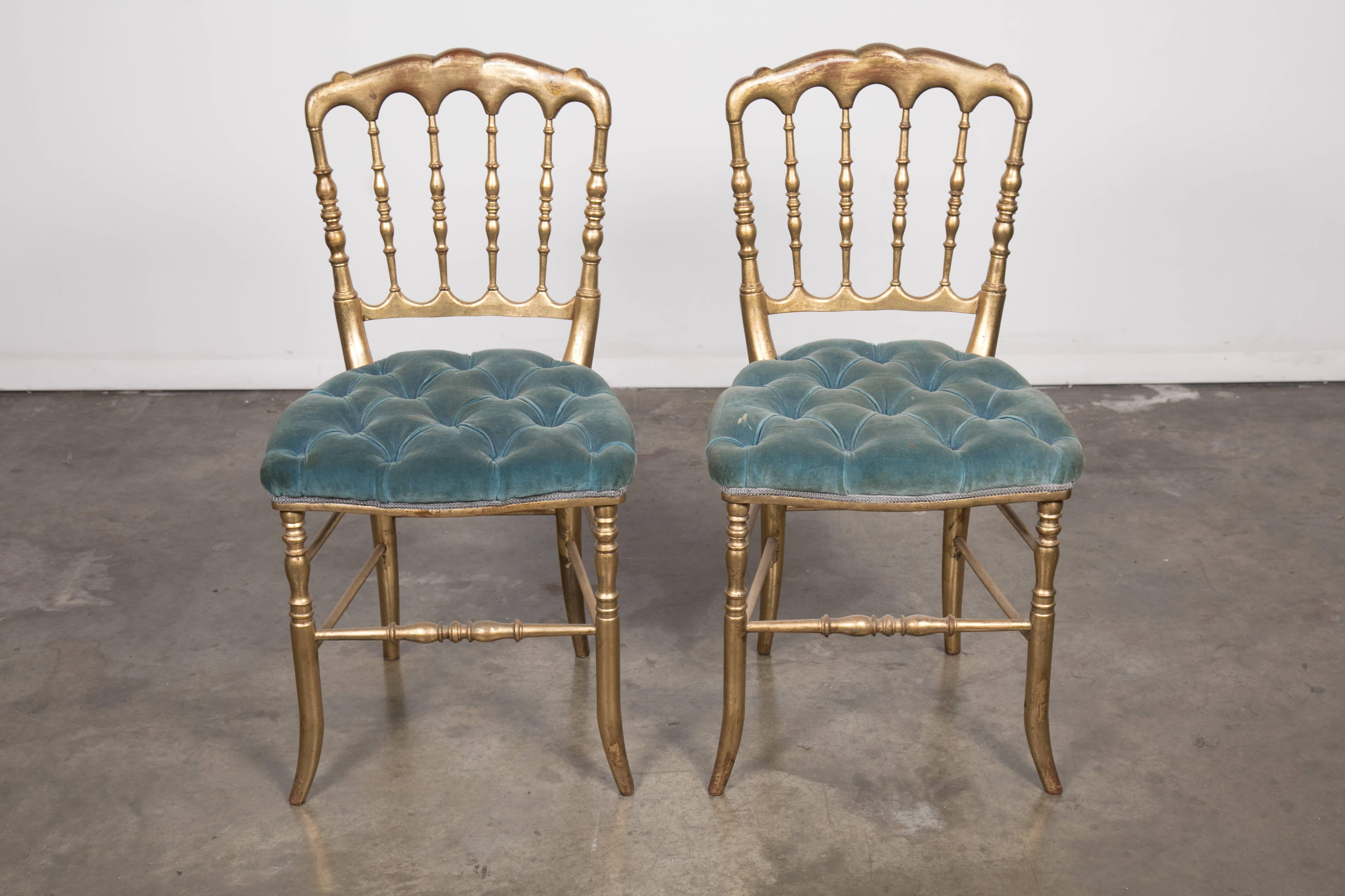Lovely pair of 19th century Napoleon III gilded opera chairs with tufted seats, Paris, circa 1860s. Red oxidation showing through the beautiful water gilded patina that is original to the chairs. Solid and sturdy.