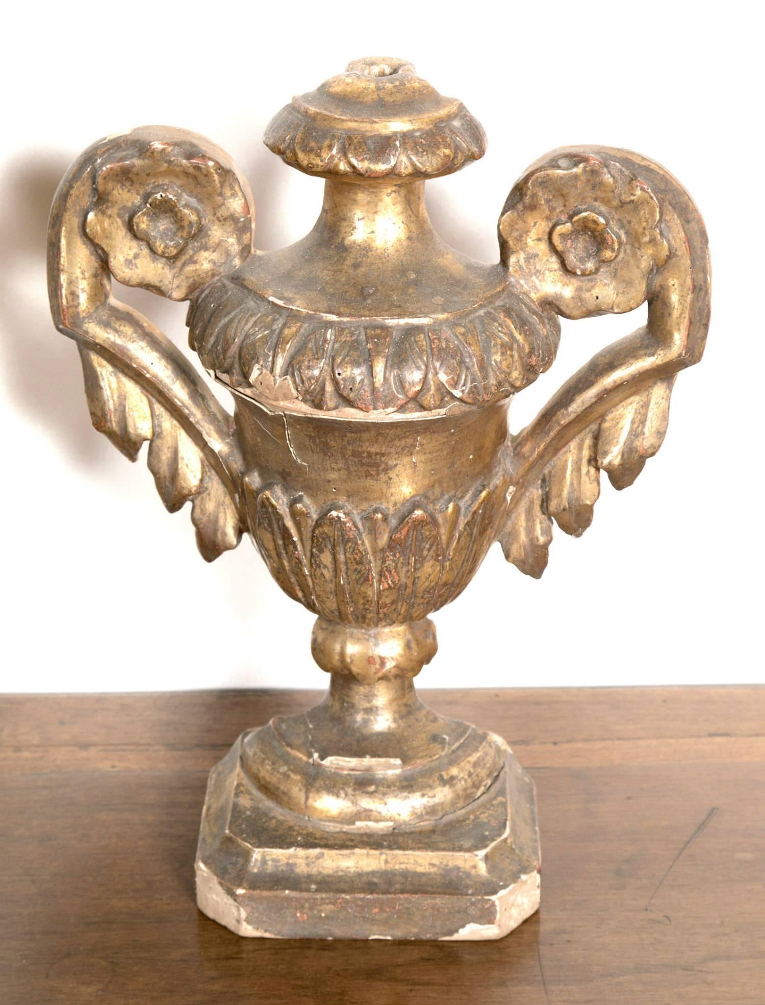 Lovely pair of 19th century hand carved giltwood Tuscan altar urns with elaborate foliate-carved, scrolling handles, raised on a fluted socle, having a round foot on a square base. Each of these Italian urns is crafted as a half with one flat side