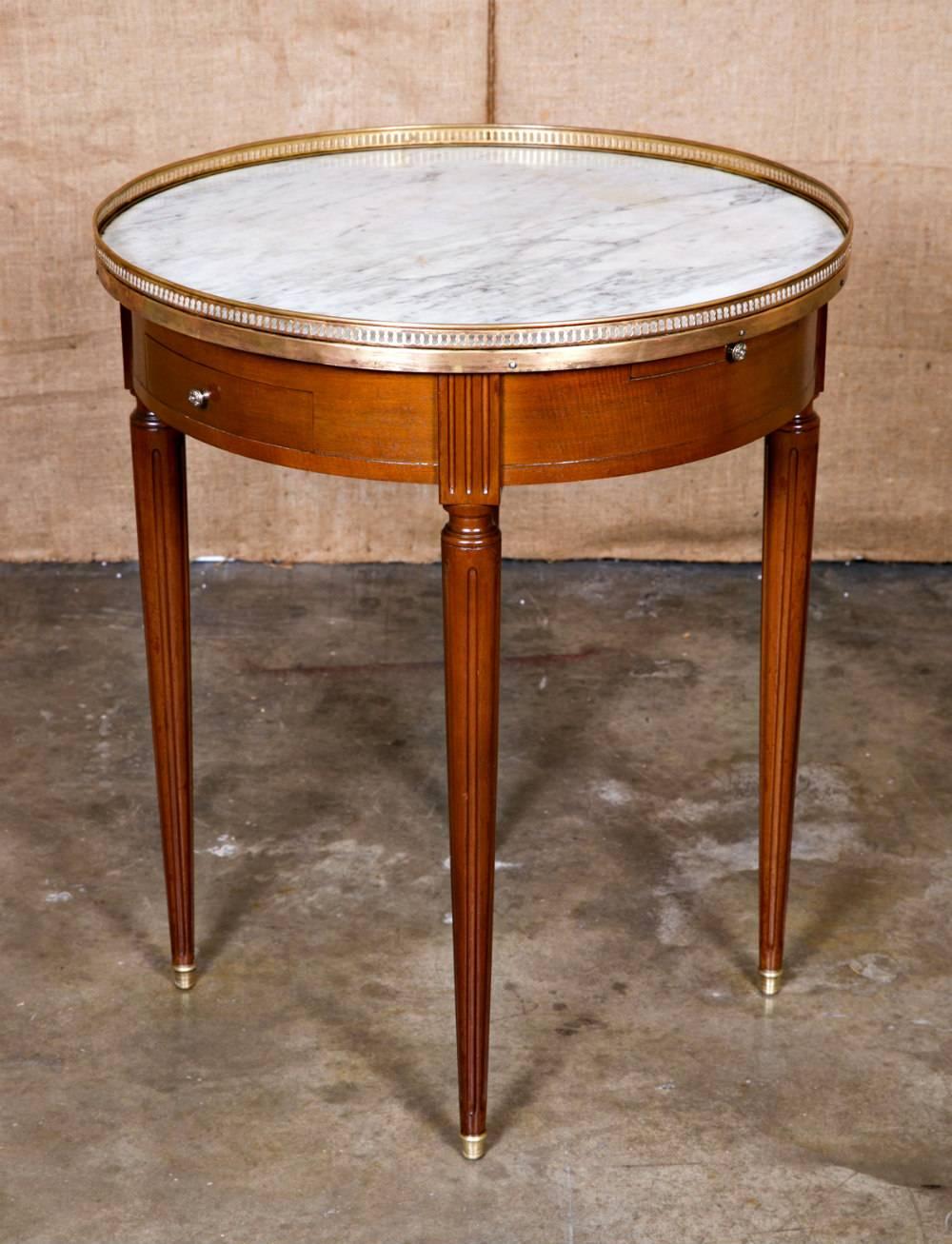 Handsome Louis XVI style bouillotte table in mahogany with a Carrara marble top surrounded by a pierced brass gallery. The apron has two drawers for cards and chips and two tirettes (pull-out utility slides) with embossed leather tops that were