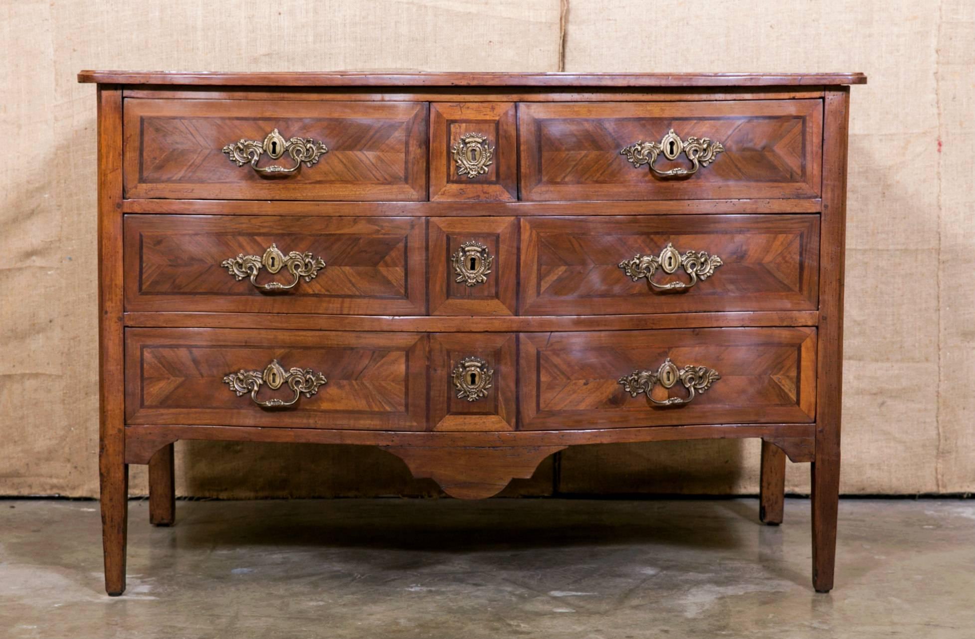 A fine late 18th century Louis XVI period parquetry commode from the Lyon region, having a serpentine front with four drawers adorned with original bronze hardware. Raised on tapered legs.

The beauty is in the refinement of the details of this