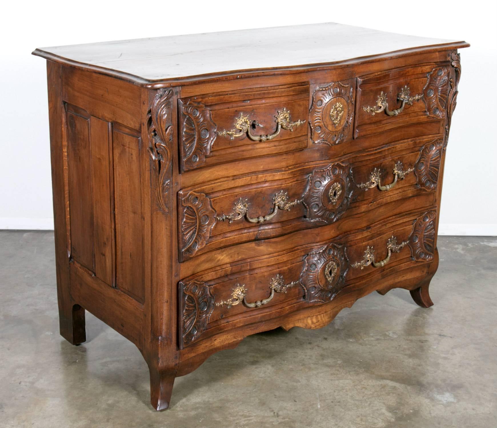 Exceptional and rare early 18th century Regence period Lyonnaise commode galbé (curved), handcrafted from select French walnut by master artisans in the region surrounding Lyon, circa 1720. Having a curved front, the drawers are arranged in a