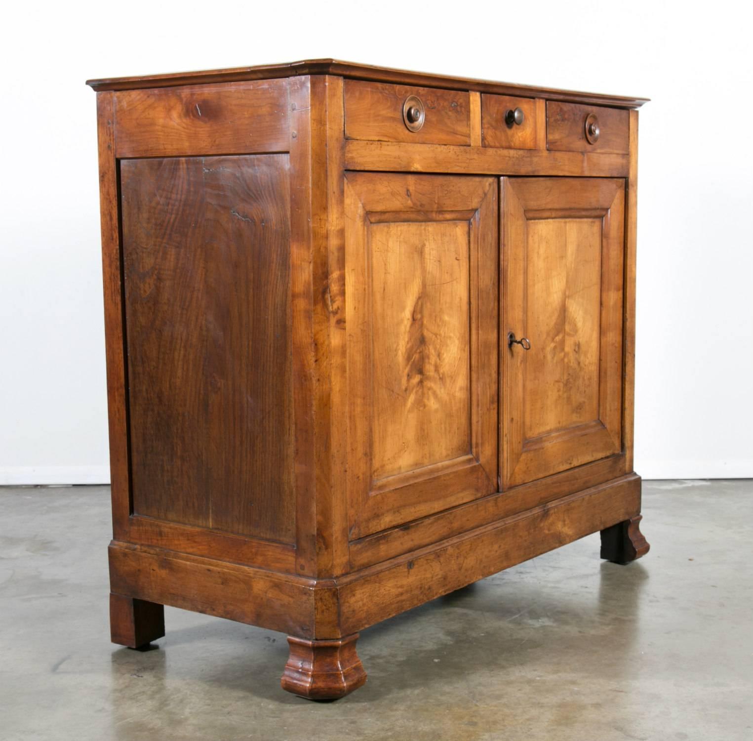 A very handsome solid cherry Louis Philippe period buffet d'appui, having three drawers over two paneled doors, resting on flat bun feet. The interior opens for great storage. This stately gentleman's buffet retains its beautiful rich, original