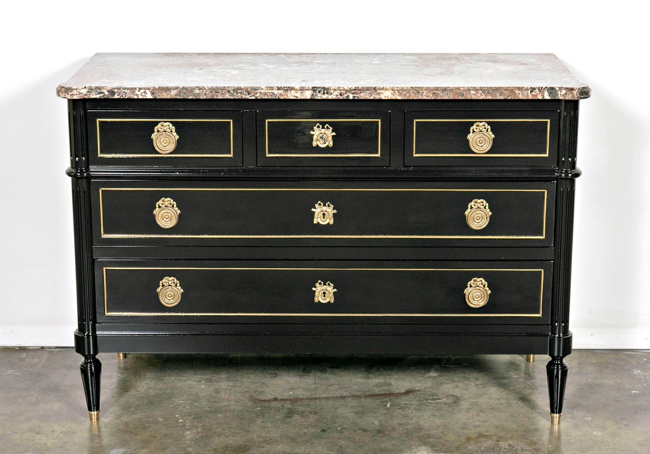 Solid mahogany Maison Jansen attributed Louis XVI style five-drawer commode, ebonized with a lustrous French polish, having a high polished Alpine Breche marble top. The five drawers retain the original bronze hardware and brass trim. Supported on