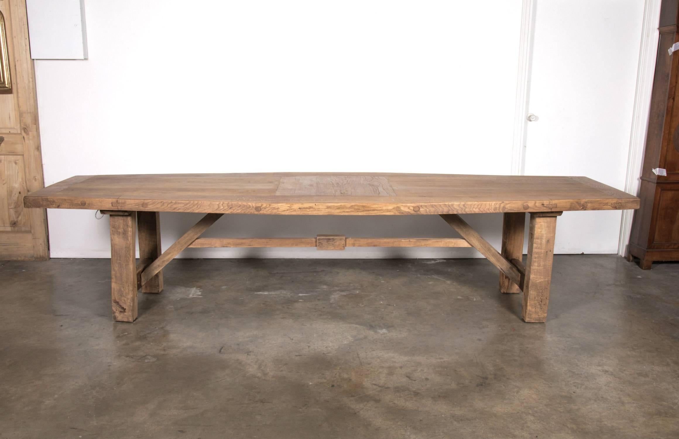 A very large bleached or washed oak French farm table handcrafted by rural artisans near the seaside resort of La Baule in southern Brittany. This wonderful 19th century French farm house trestle table is of superior quality to any modern table,