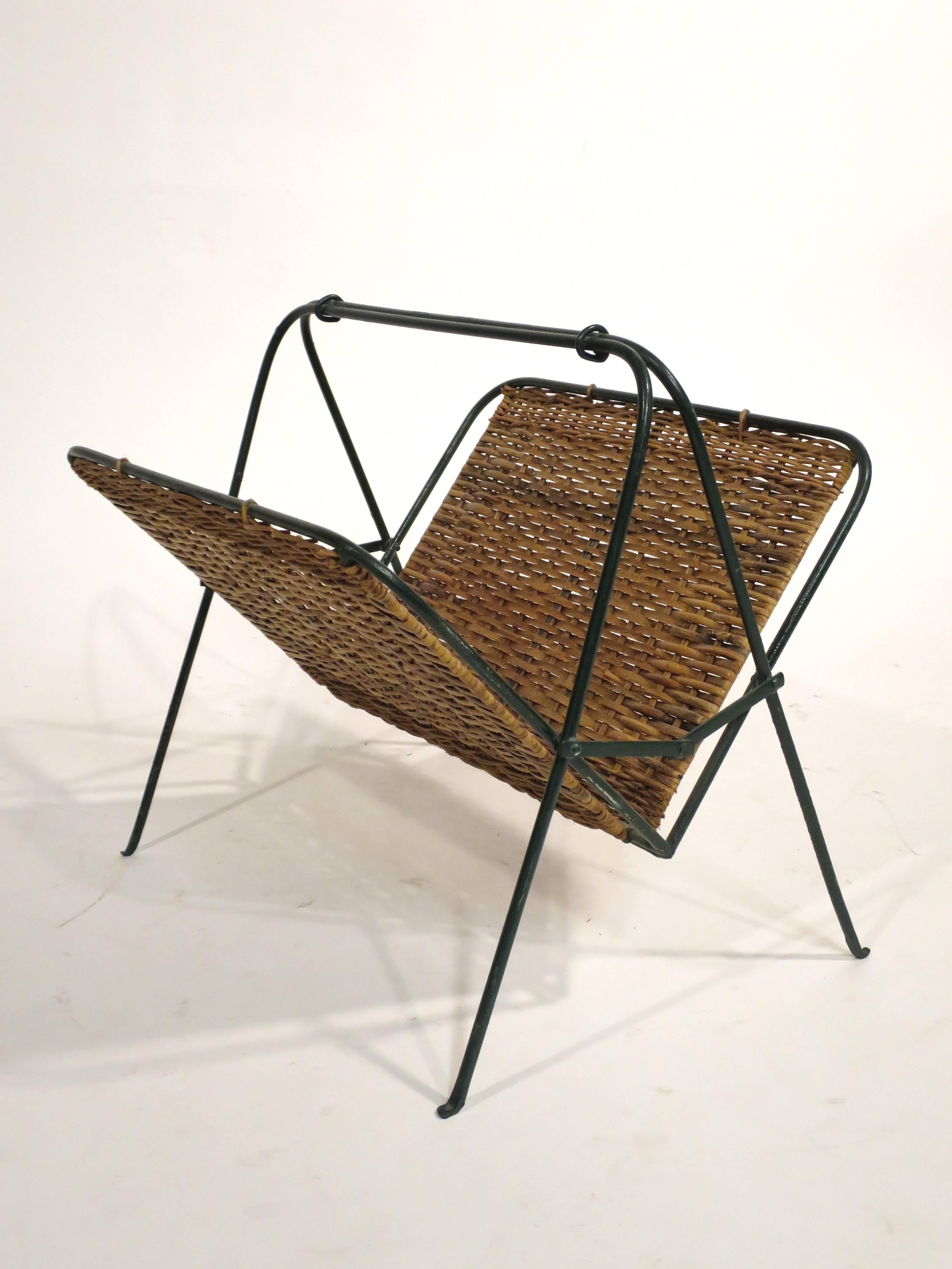 Mid-Century collapsible rattan and iron magazine rack, circa 1950s.
Complimentary shipping in the lower 48.